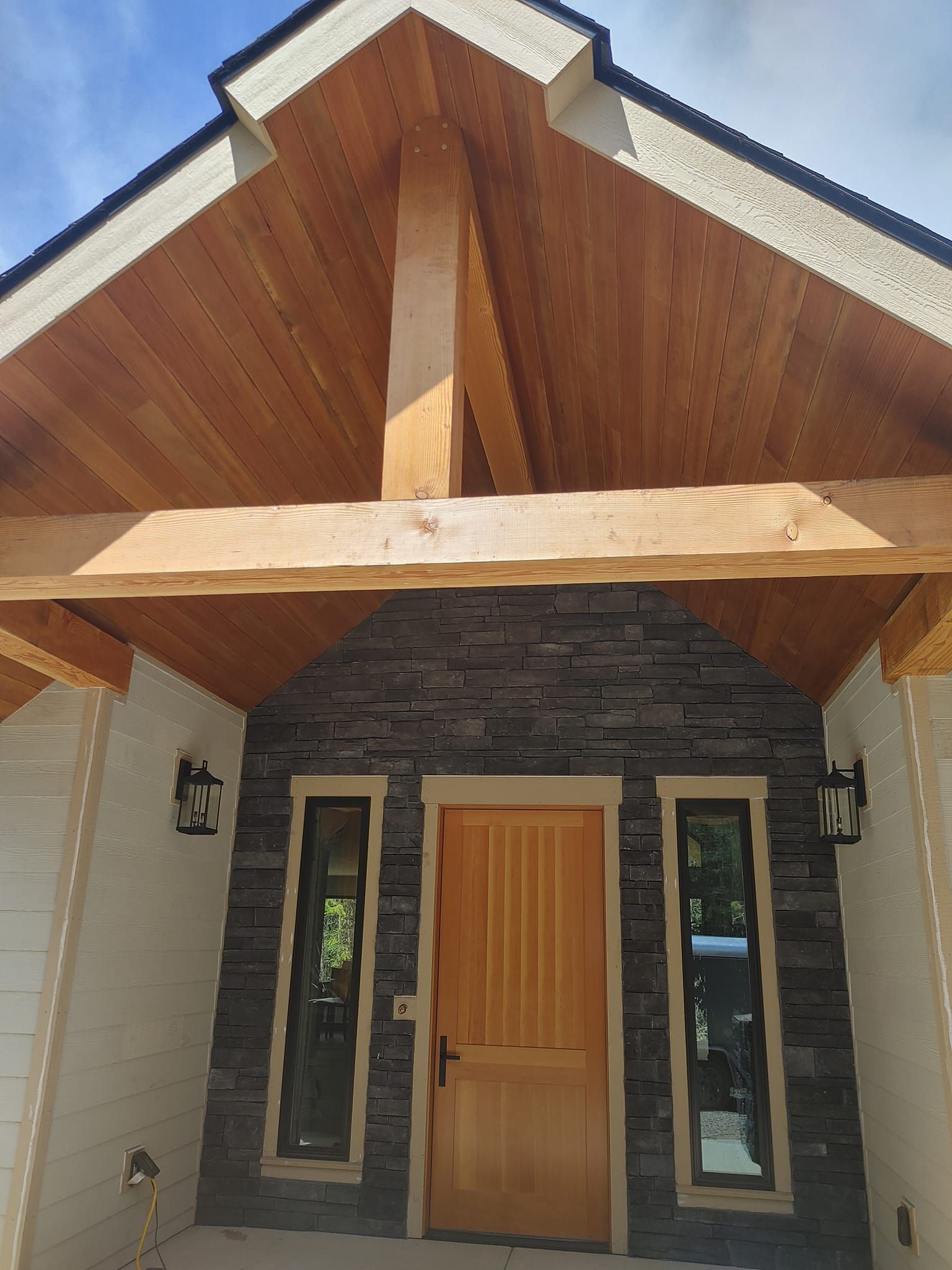 The front of a house with a wooden roof and a wooden door.
