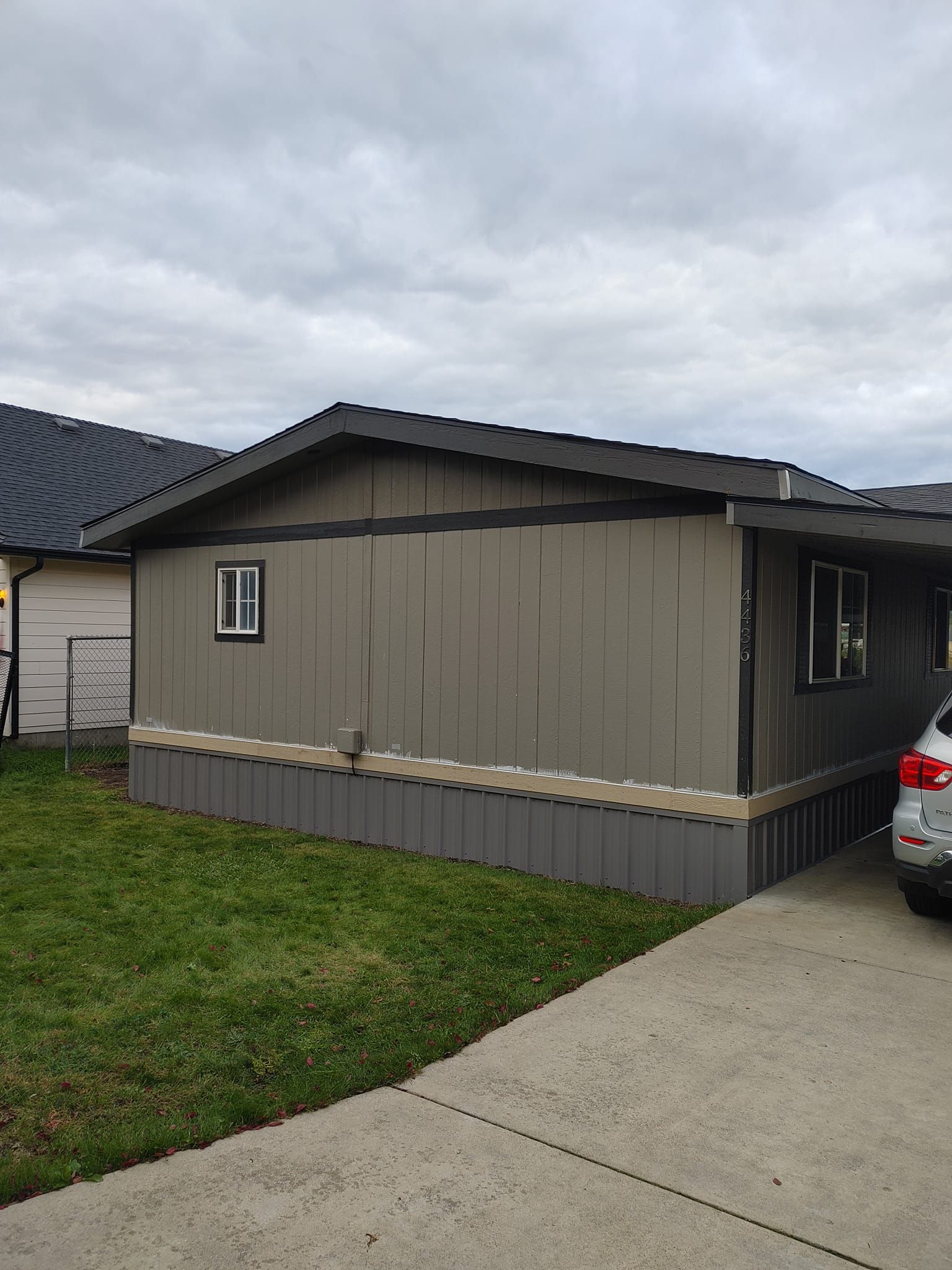A mobile home with a car parked in front of it.