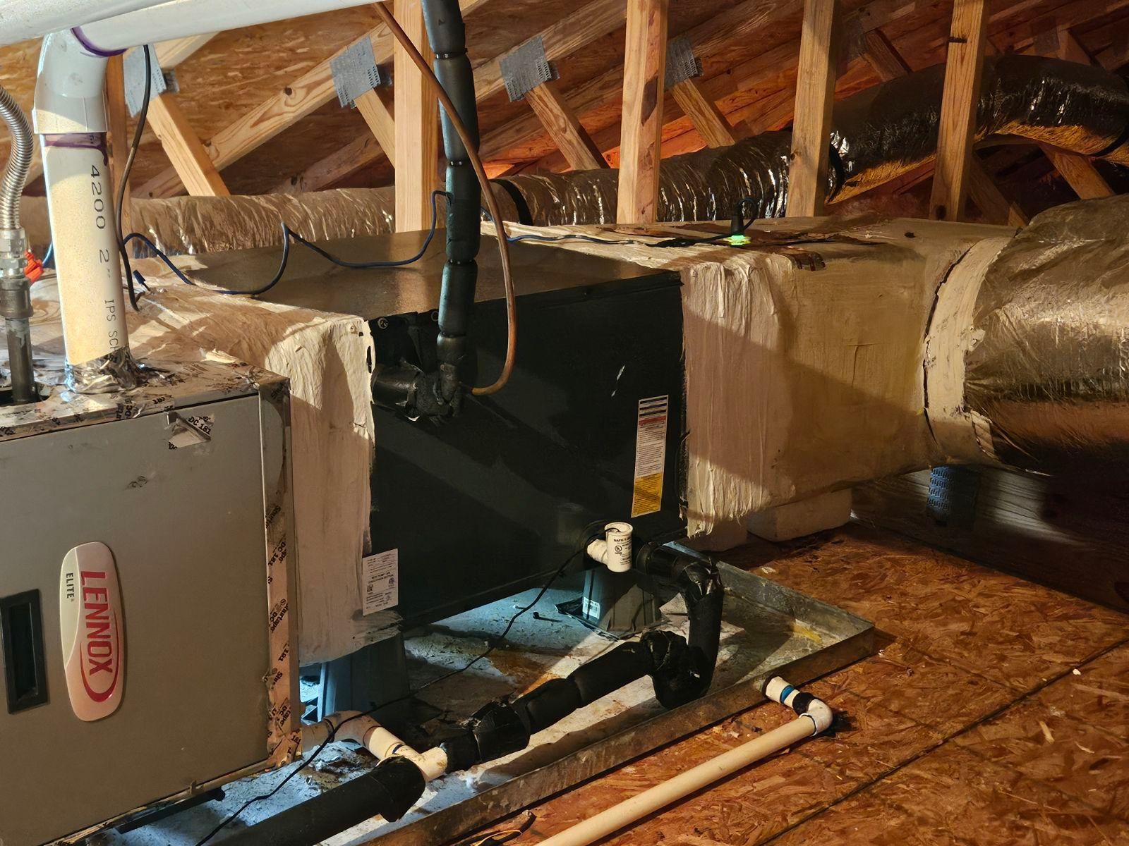 An air conditioner is sitting in the attic of a house.