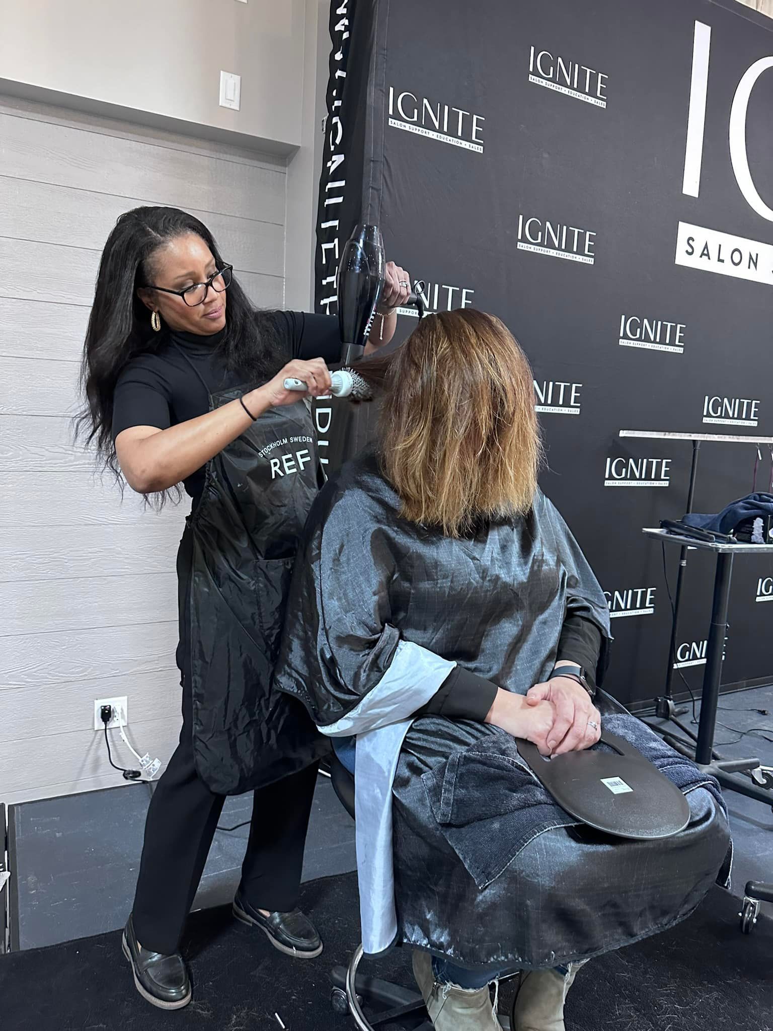 A woman is getting her hair cut by a hairdresser in a salon.