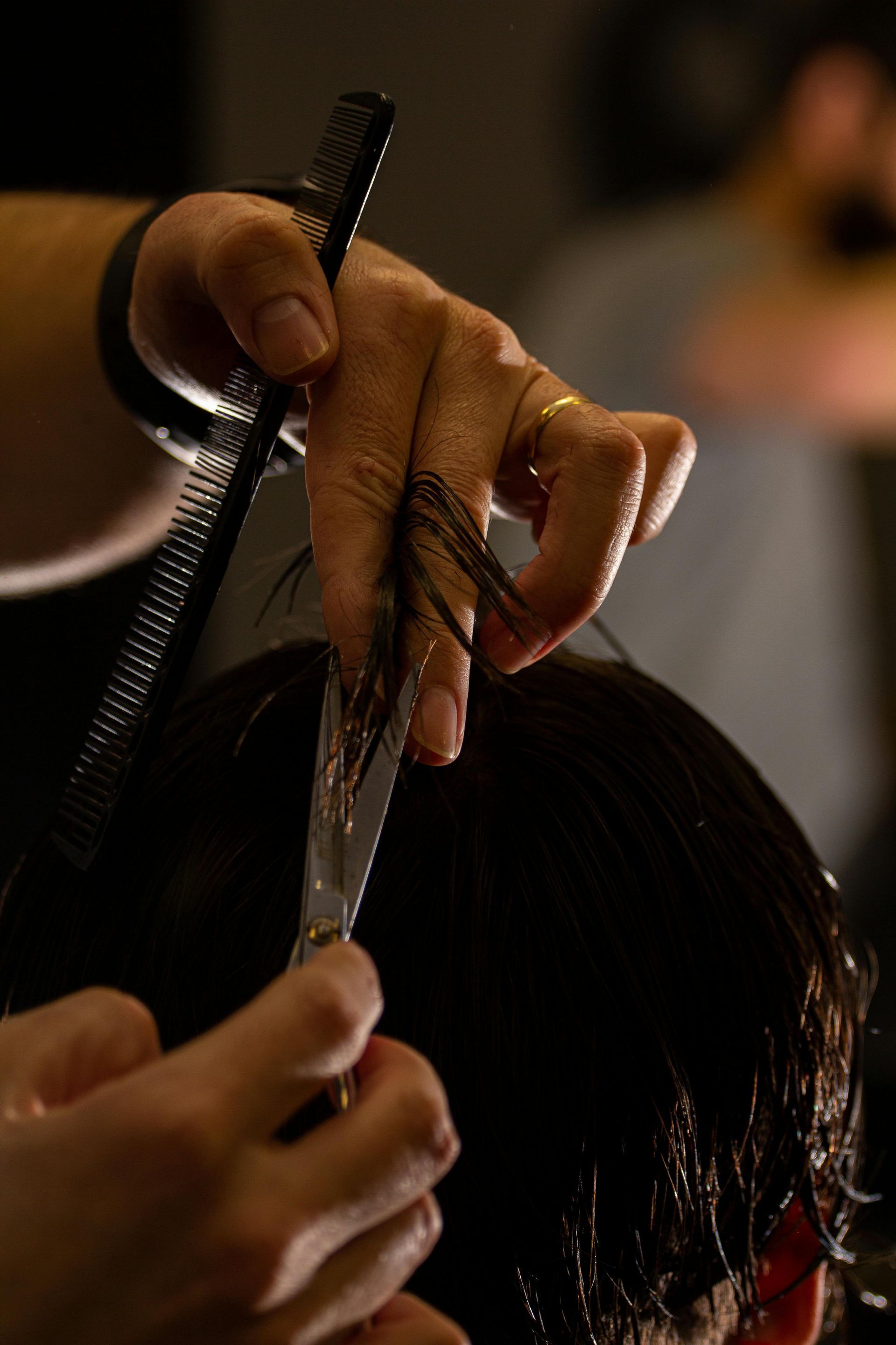 A woman is getting her hair cut by a hairdresser.