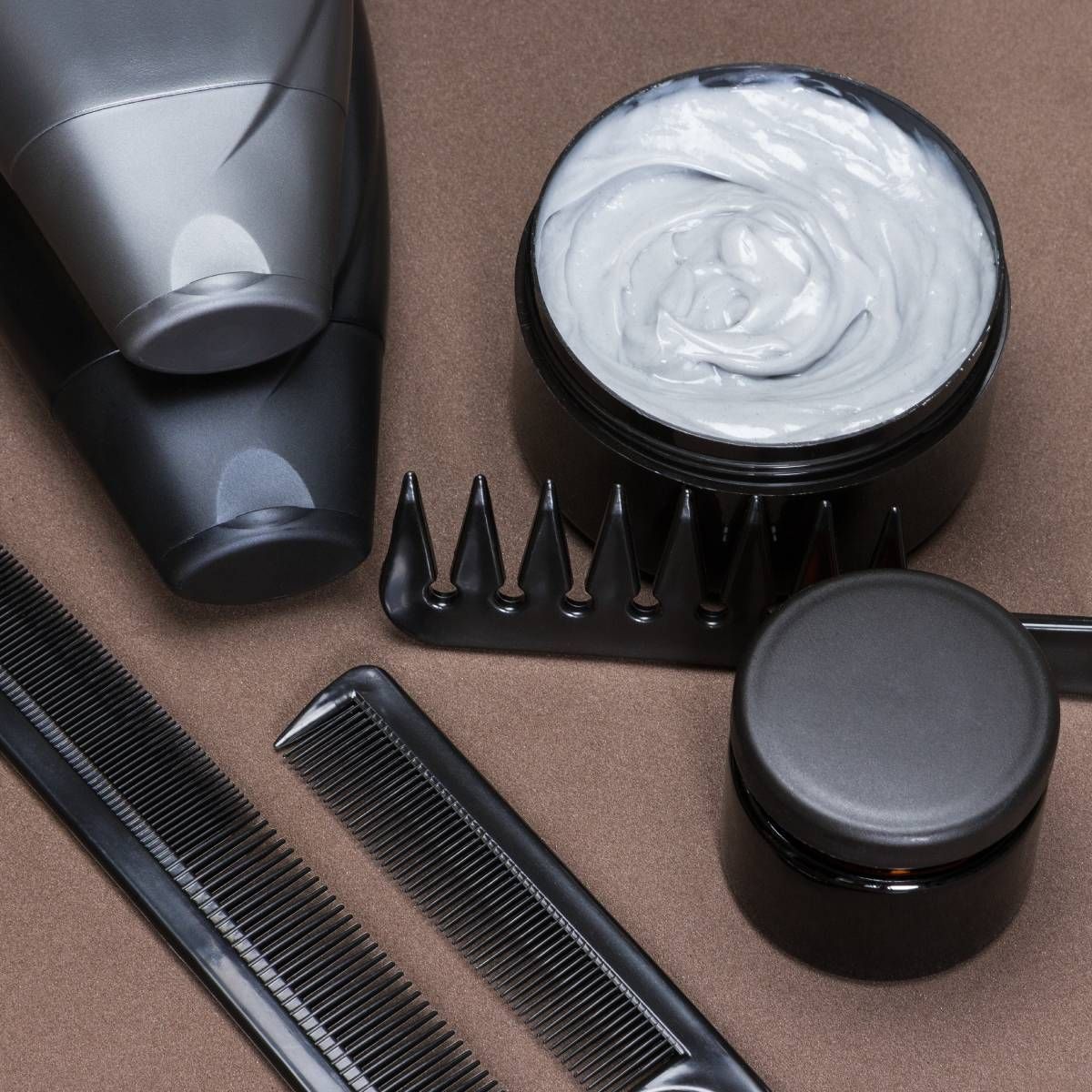 A comb a jar of cream and a bottle of shampoo