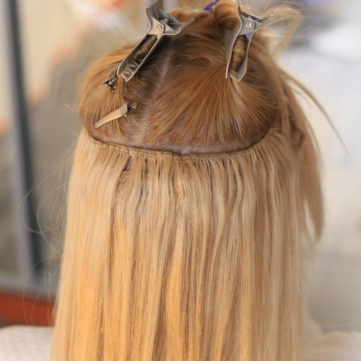 A close up of a woman 's hair with clips in it