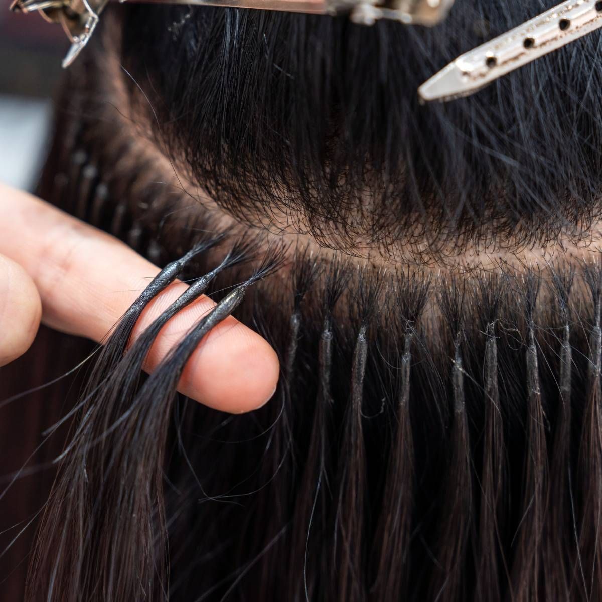 A close up of a person 's hair extensions being applied