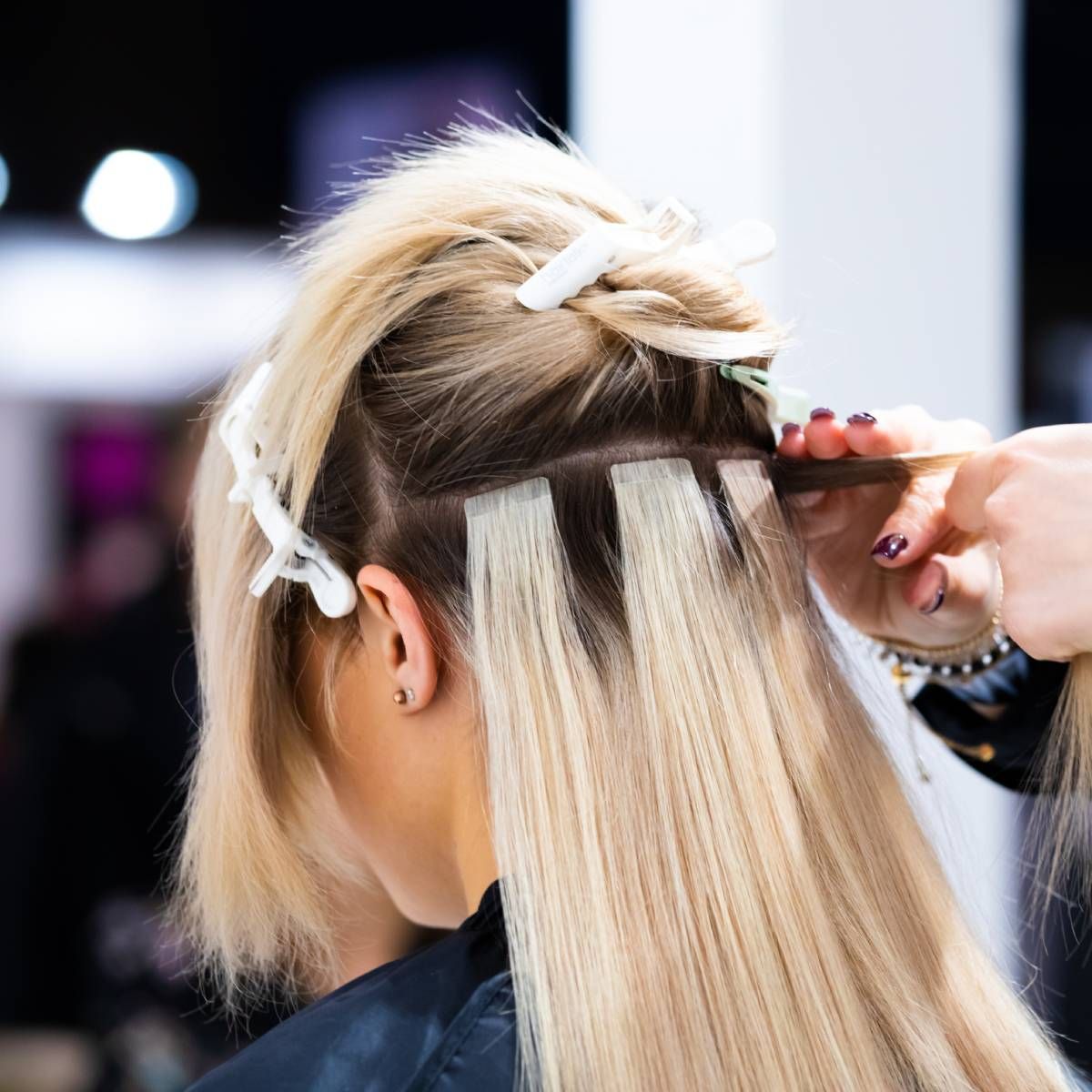A woman is getting her hair done by a hairdresser