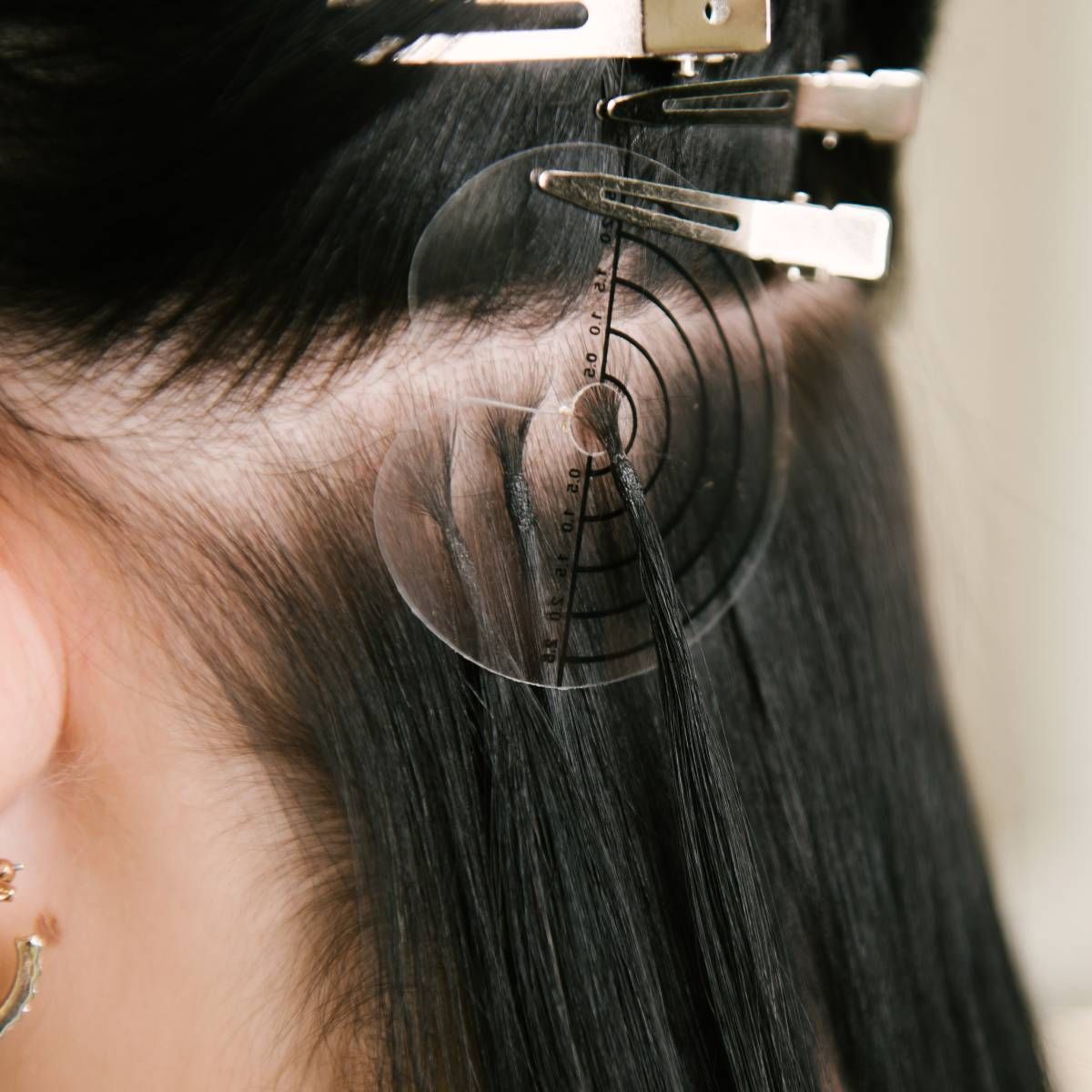 A woman 's hair is being measured with a ruler