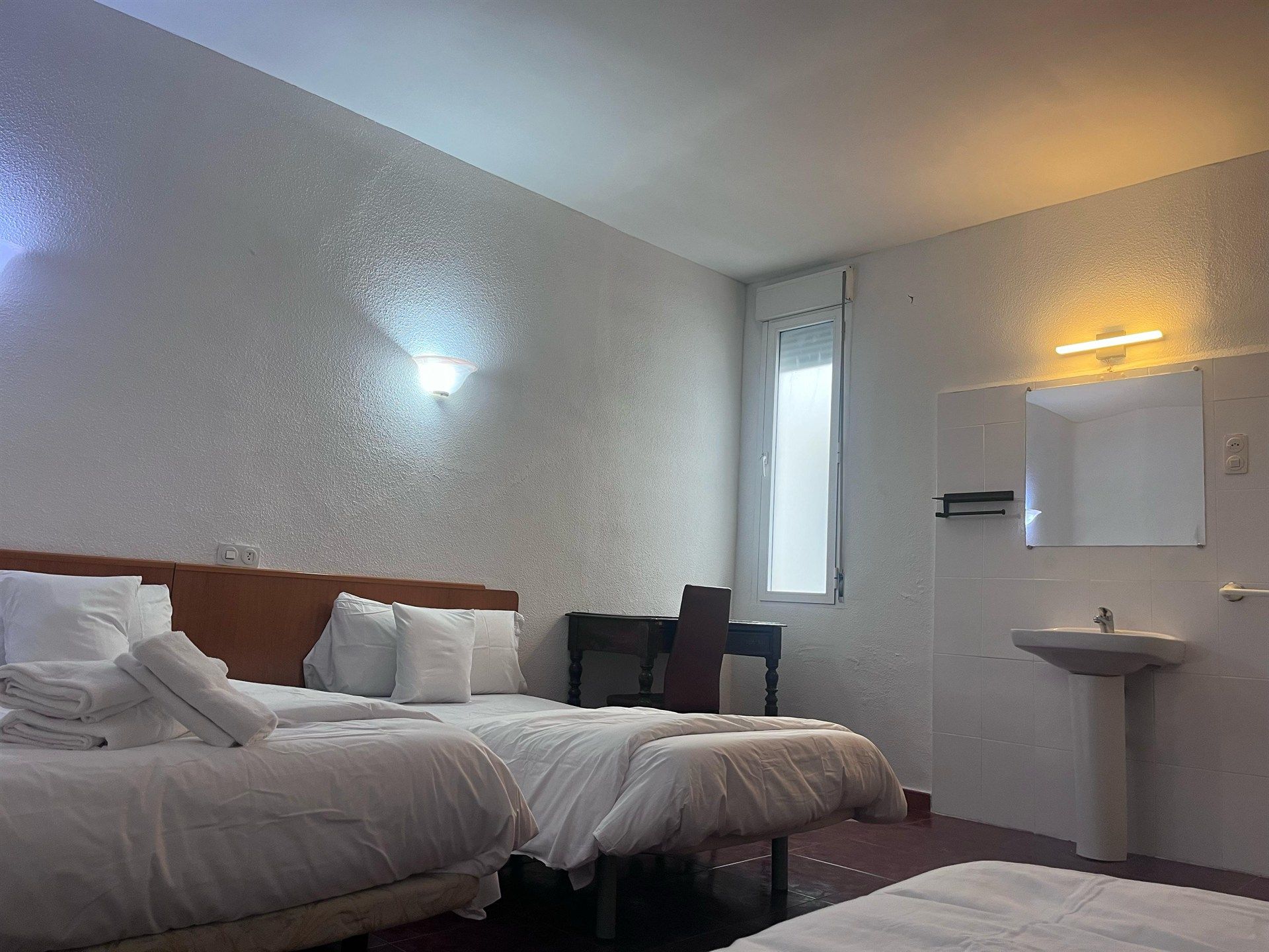 A hotel room with two beds and a sink