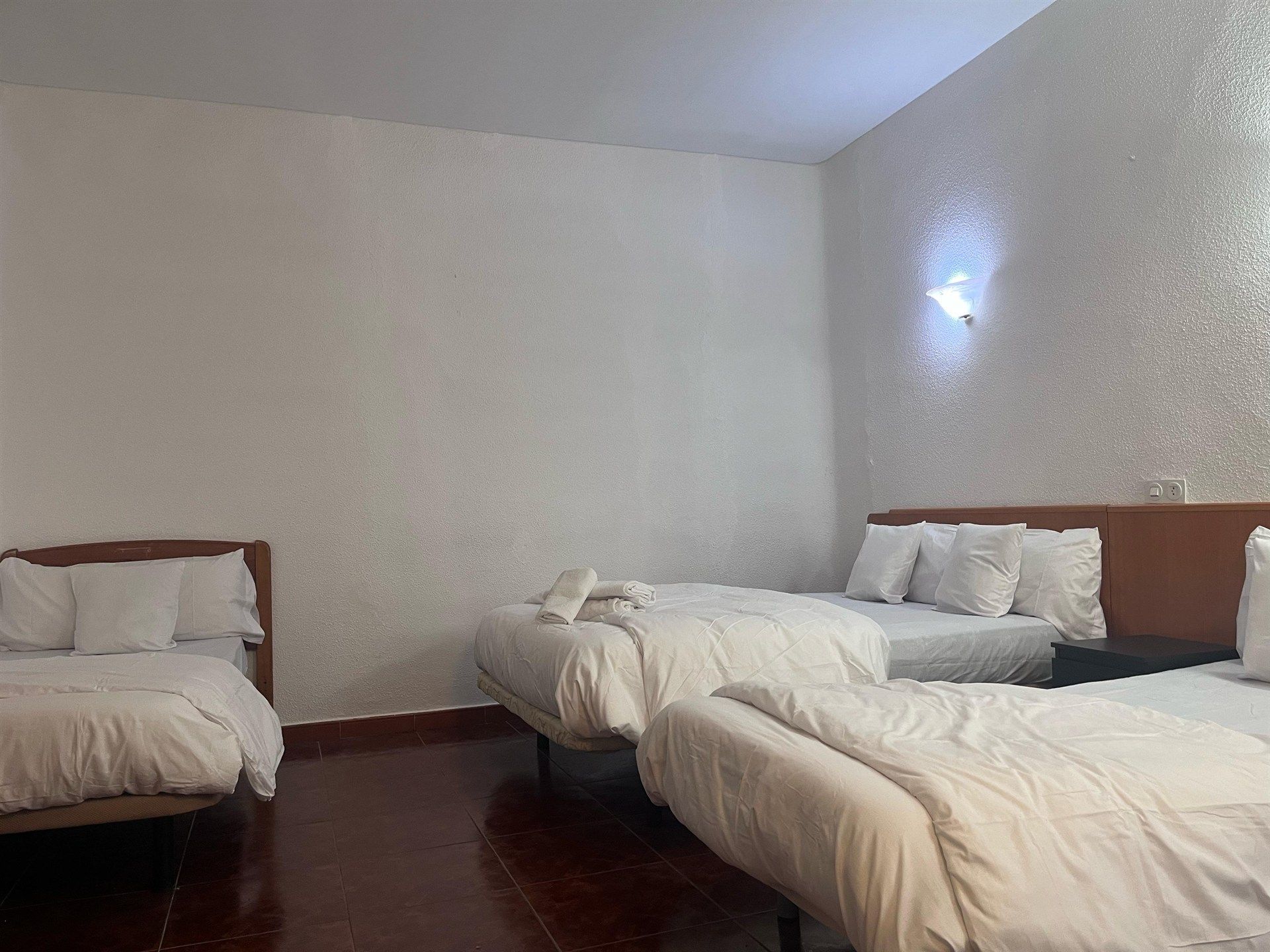 A hotel room with three beds and a couch.