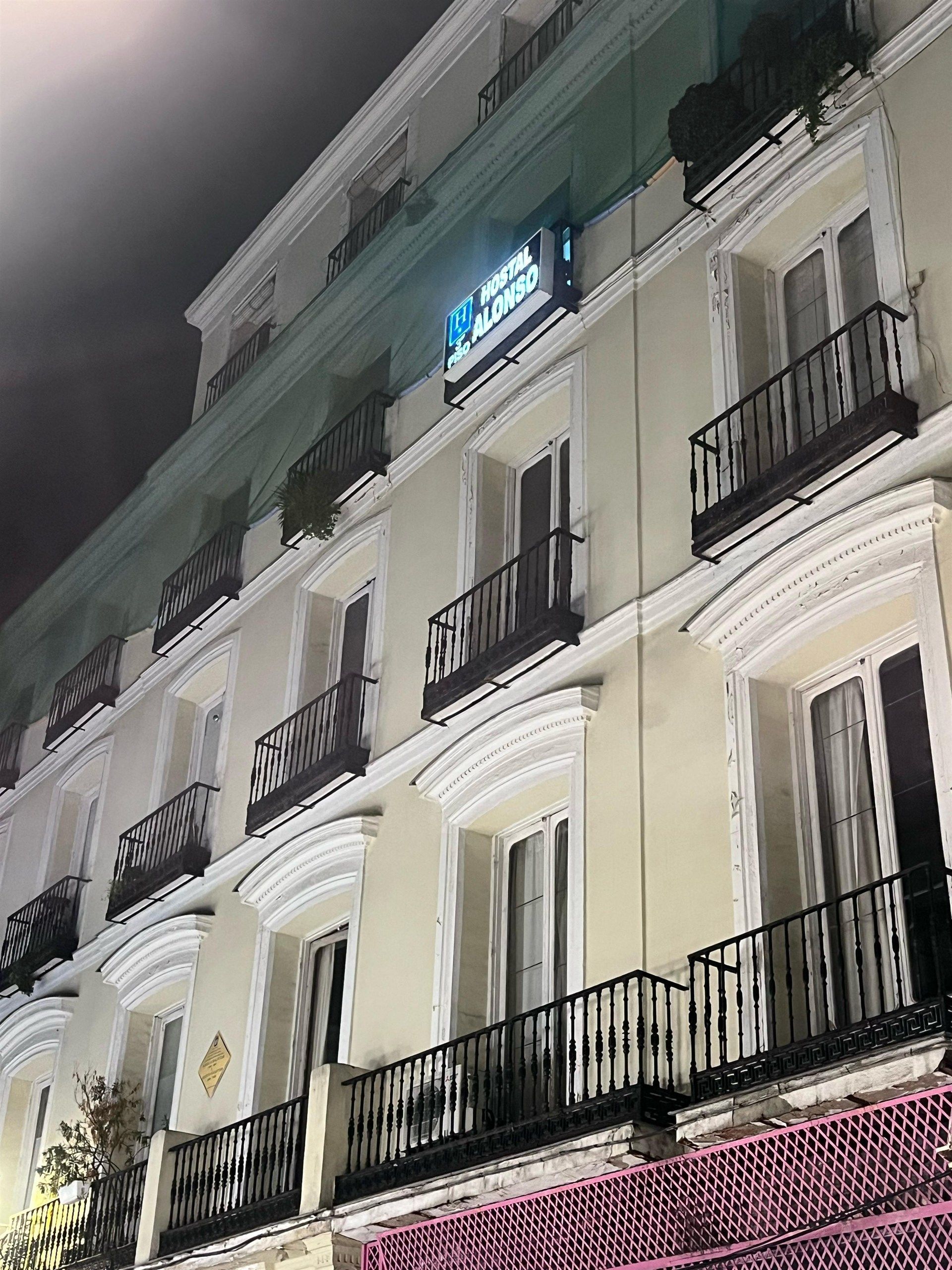 A large building with a lot of windows and balconies at night.