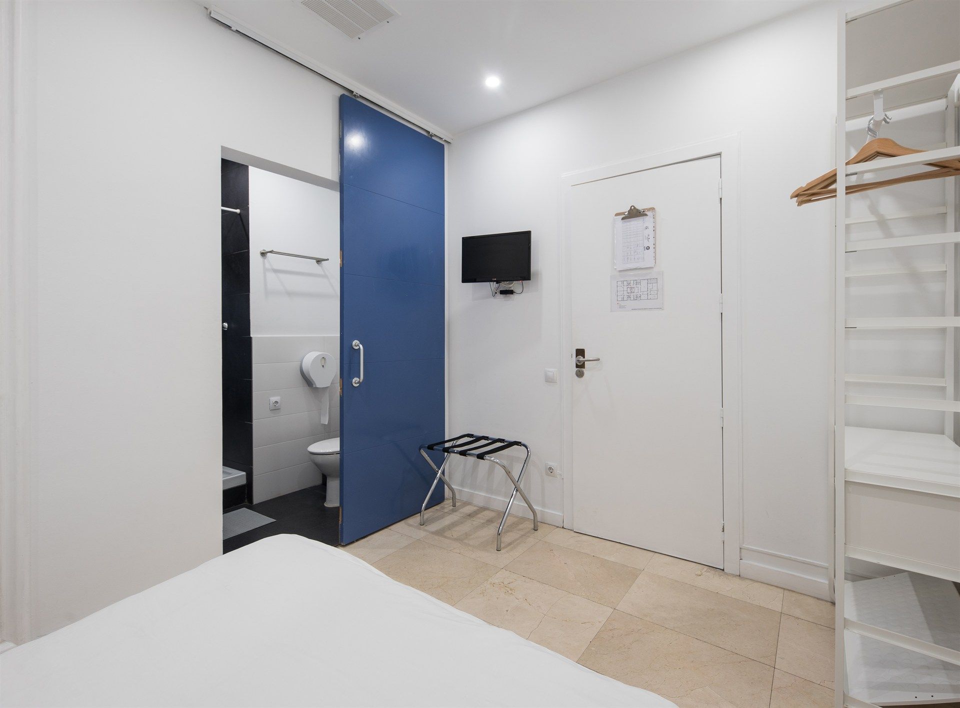 A hotel room with a sliding door leading to a bathroom.