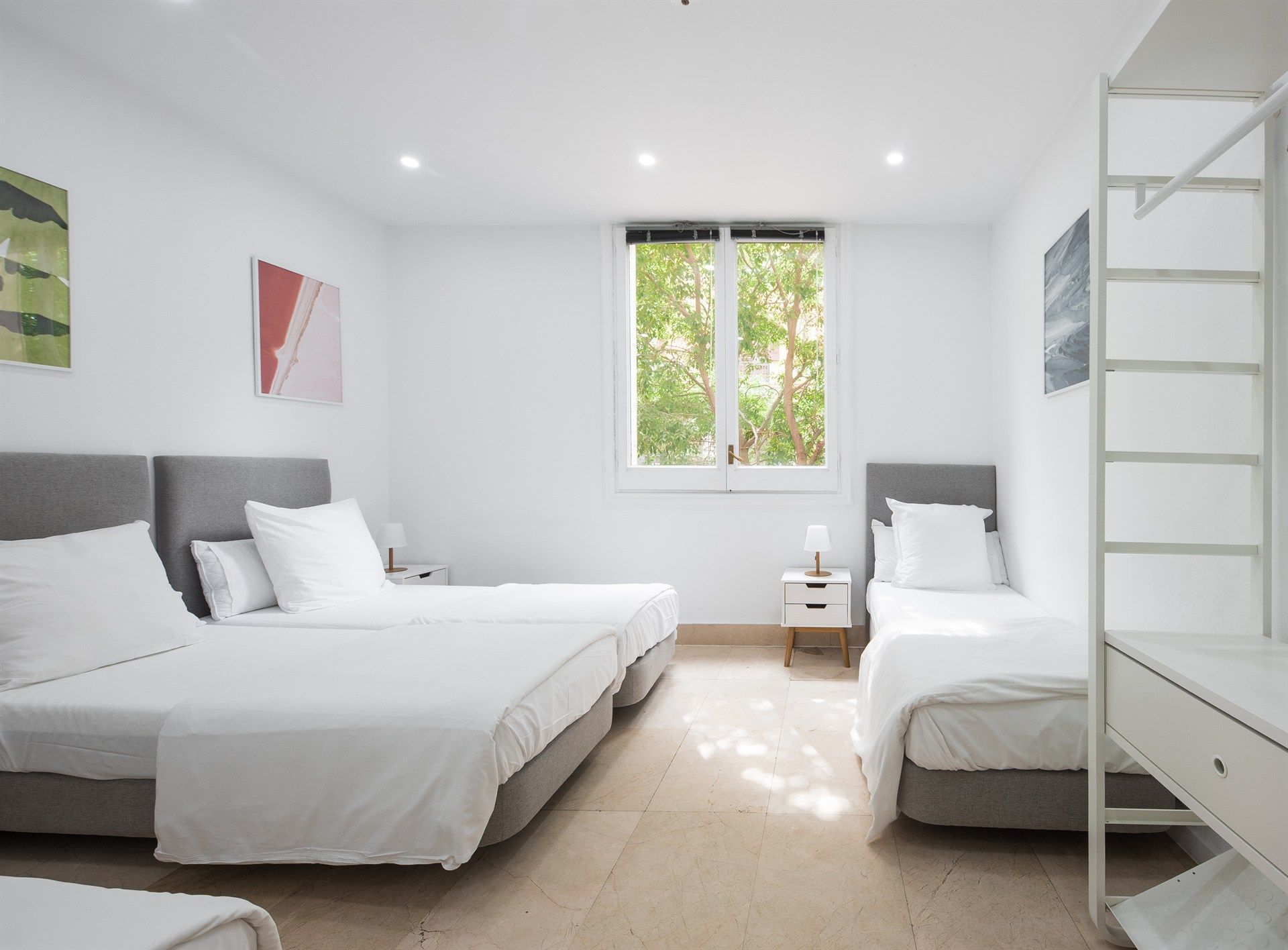 A bedroom with three beds and a bunk bed.