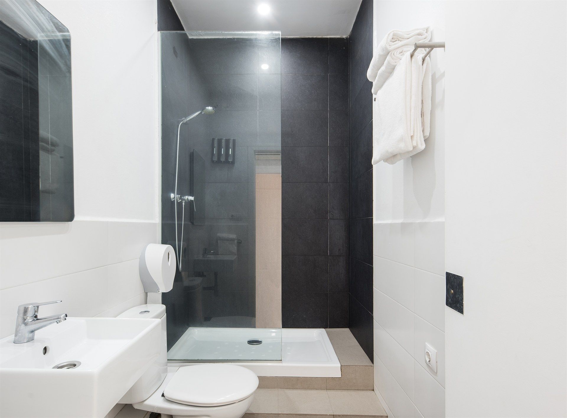 A bathroom with a toilet , sink and walk in shower.