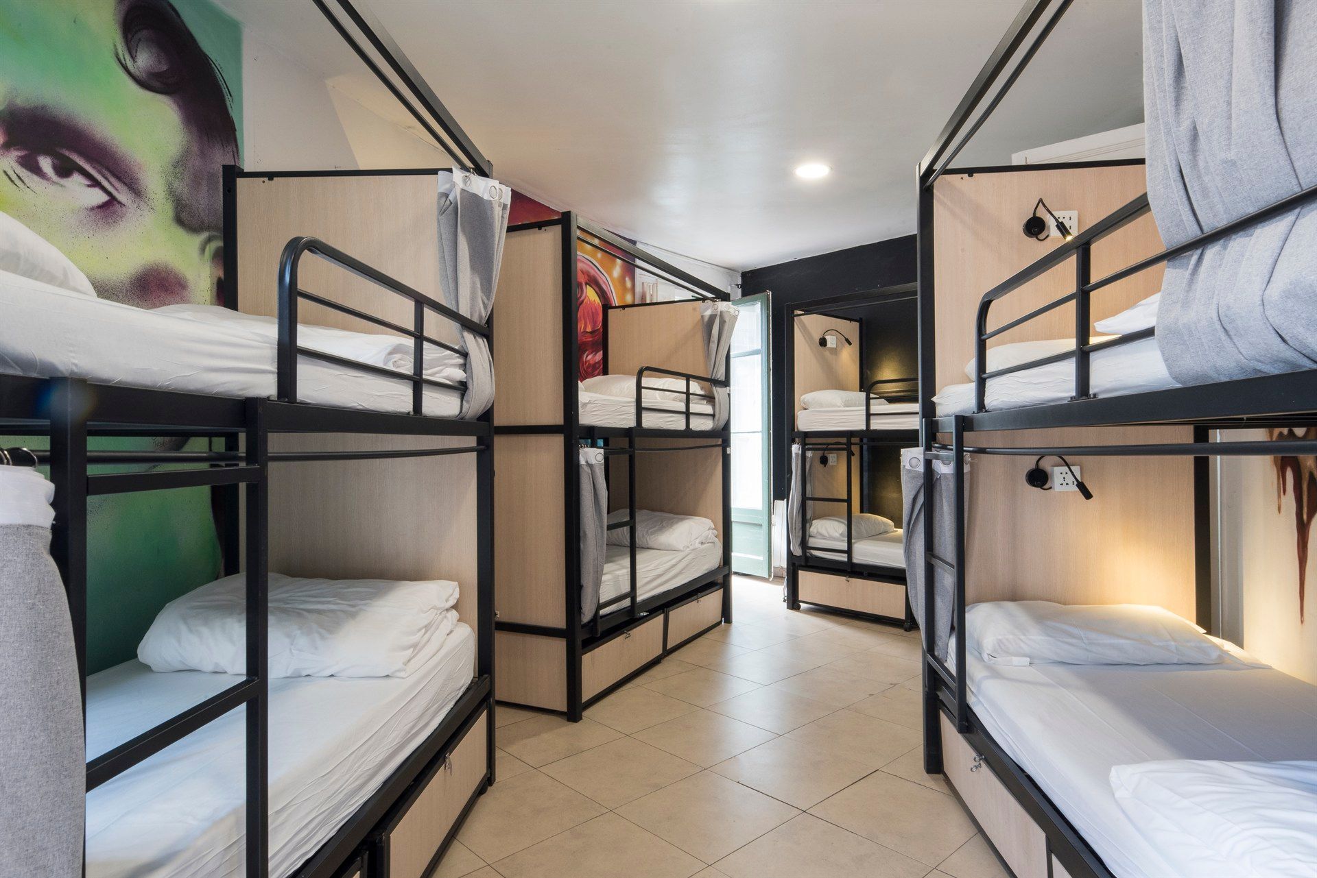 A room filled with bunk beds and a painting on the wall.