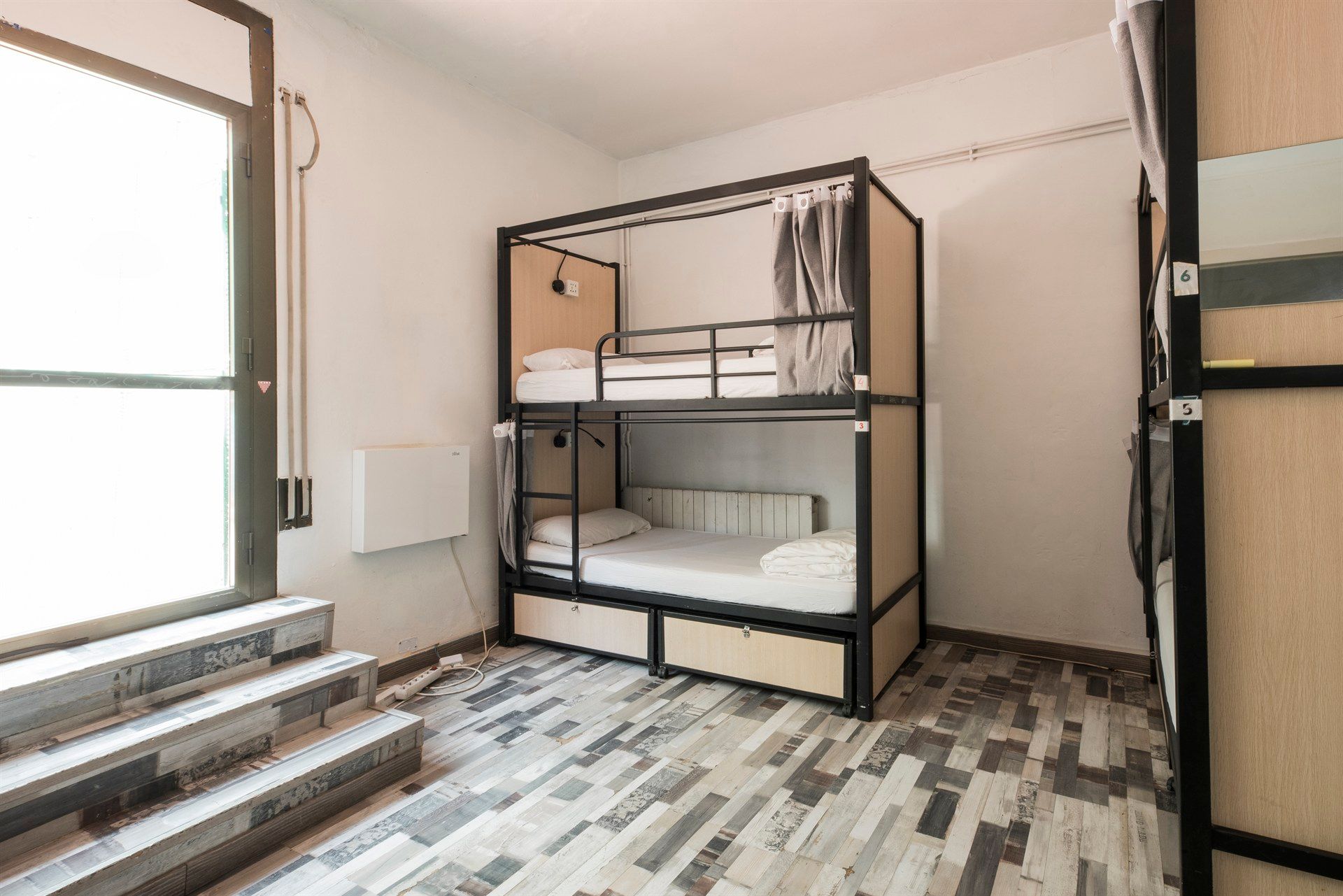 A bunk bed in a room with stairs and a window.