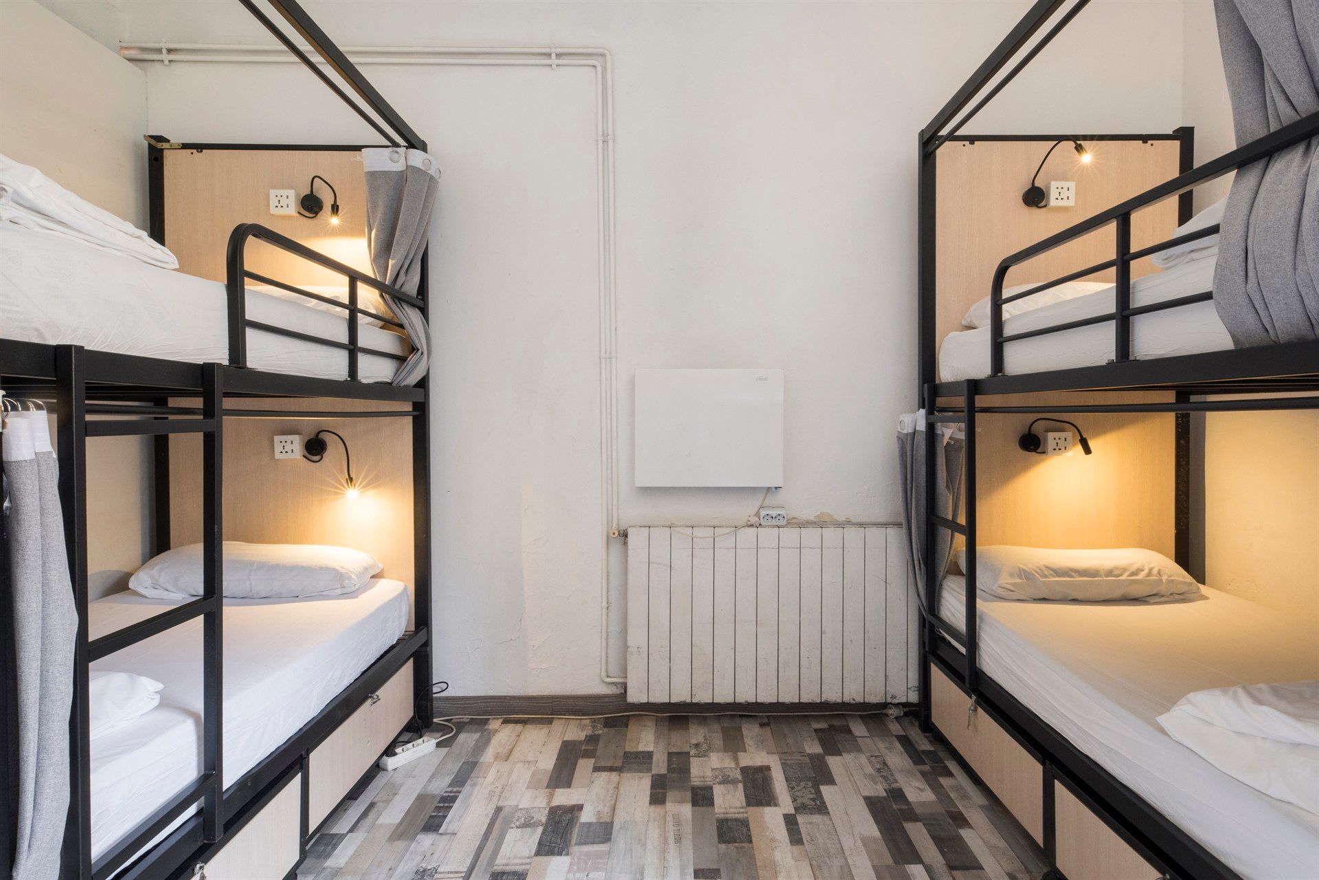 A room with four bunk beds and a radiator.