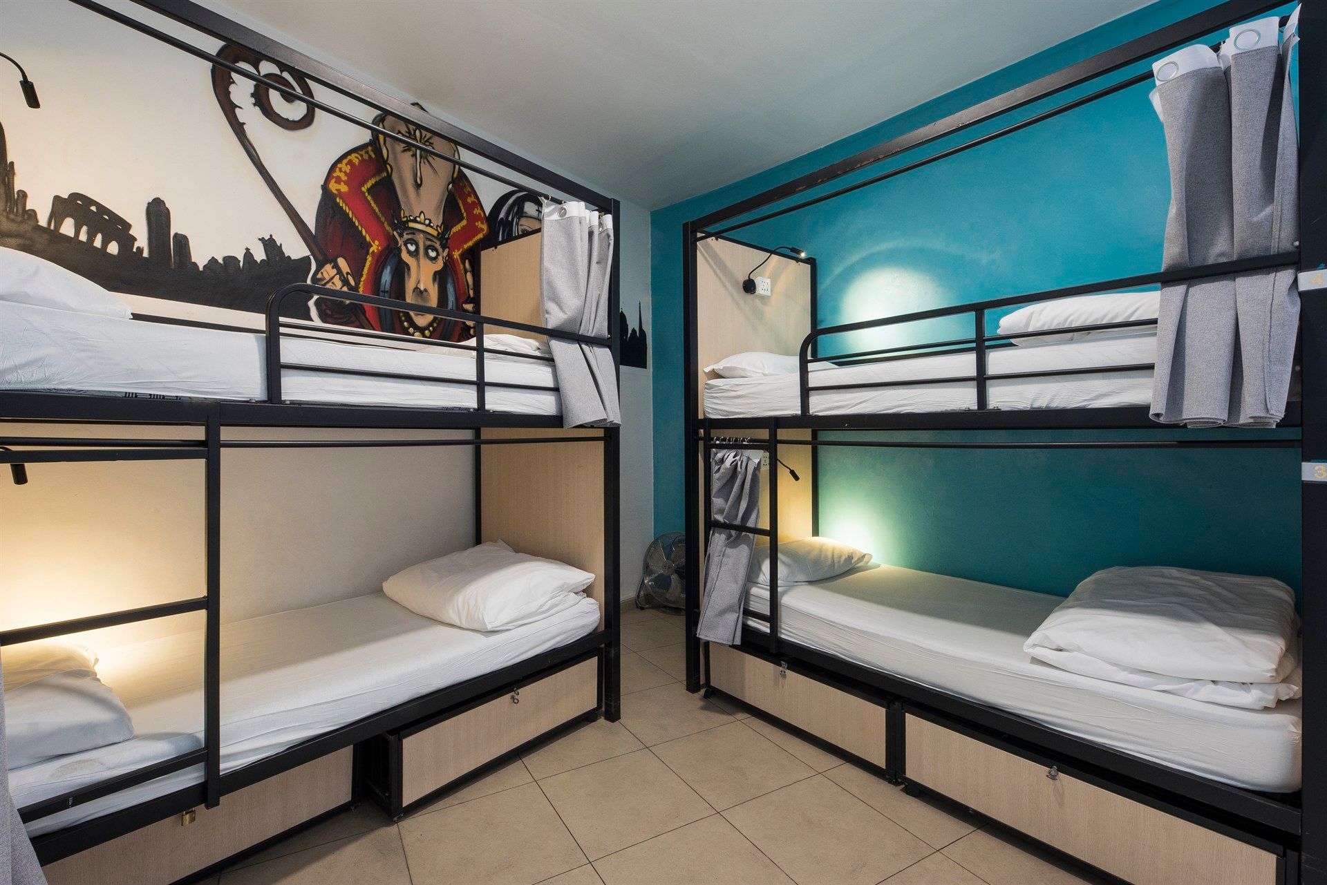 A room with four bunk beds and a painting on the wall.