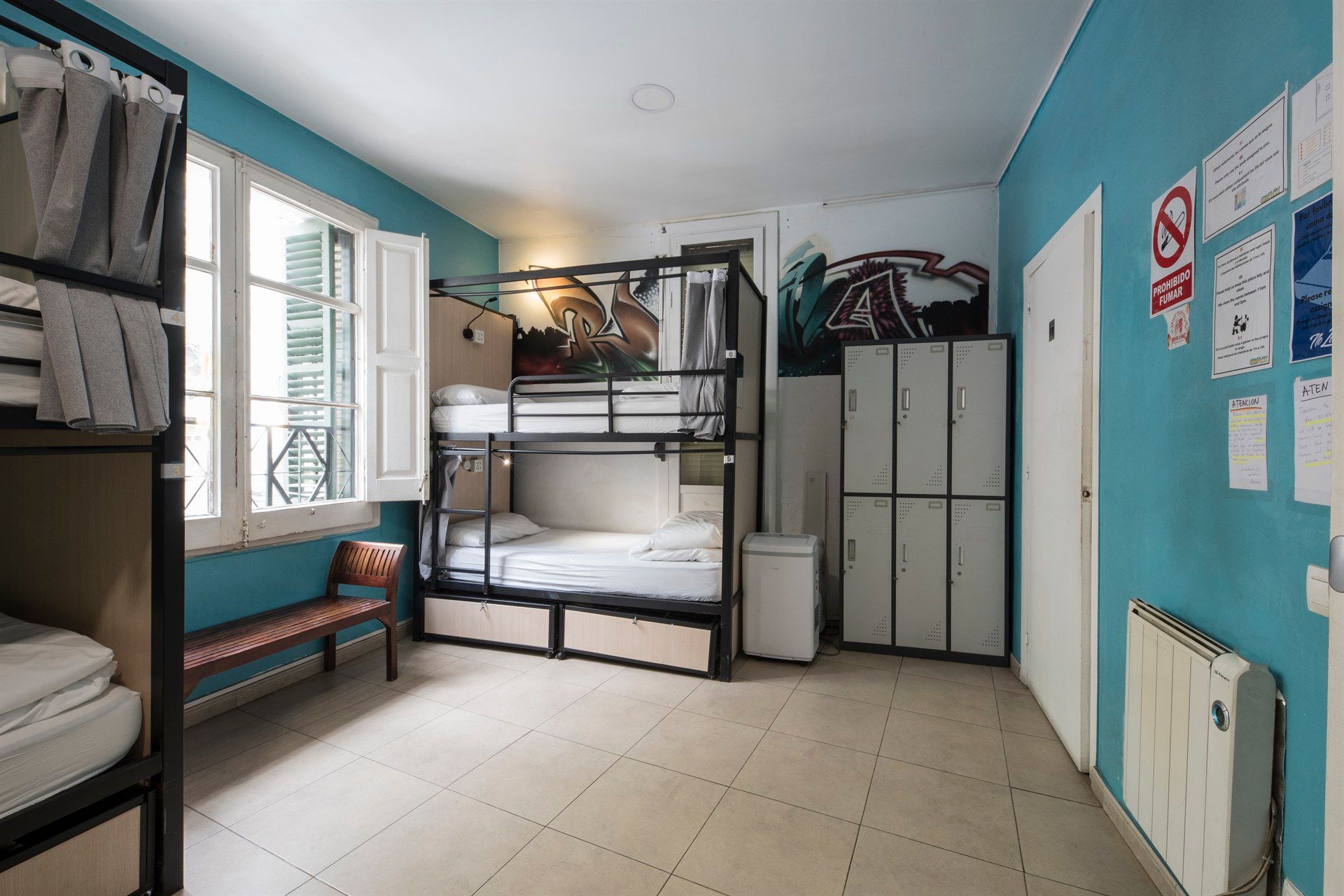 A room with bunk beds , lockers , and a window.