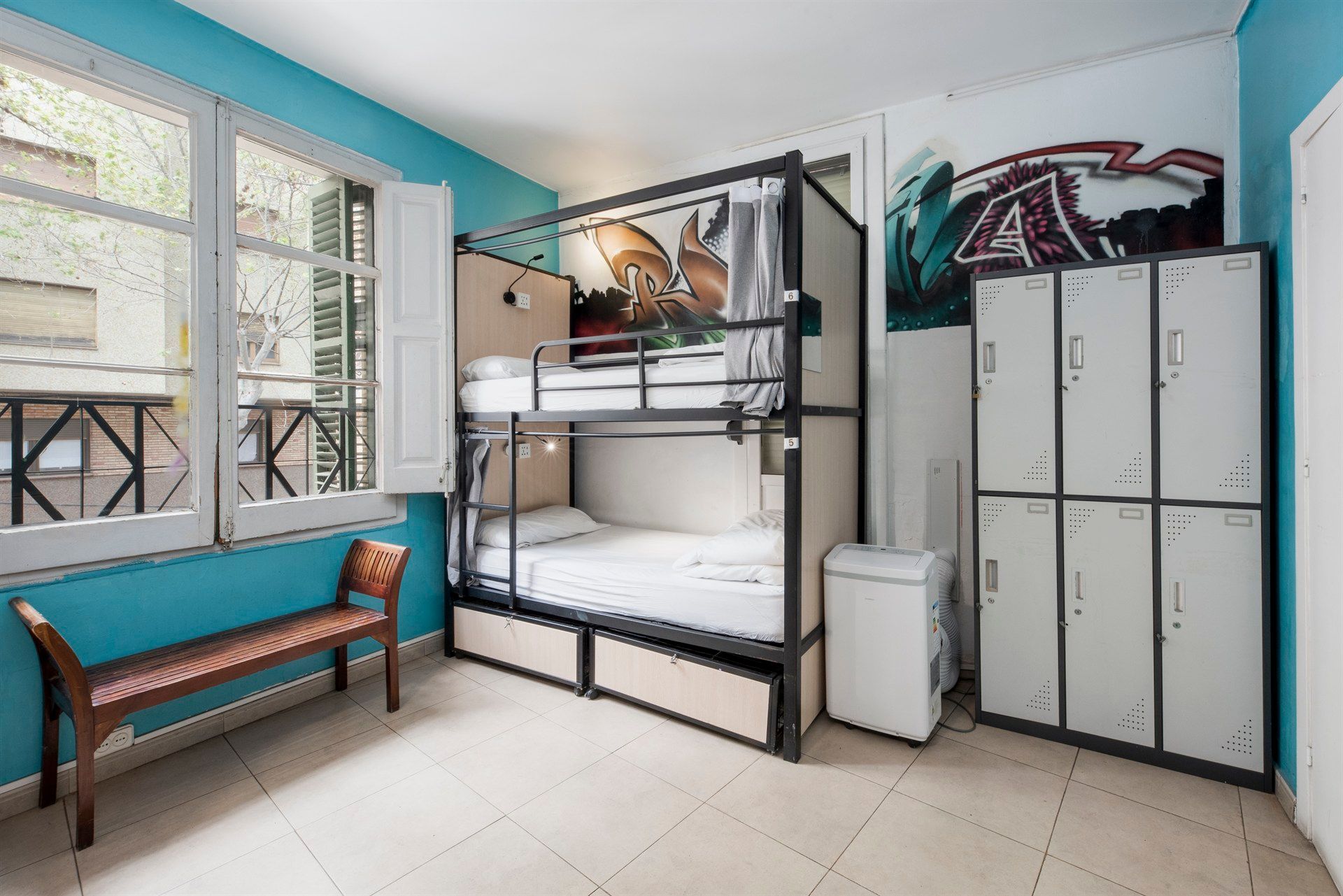 A bunk bed in a room with lockers and a bench.