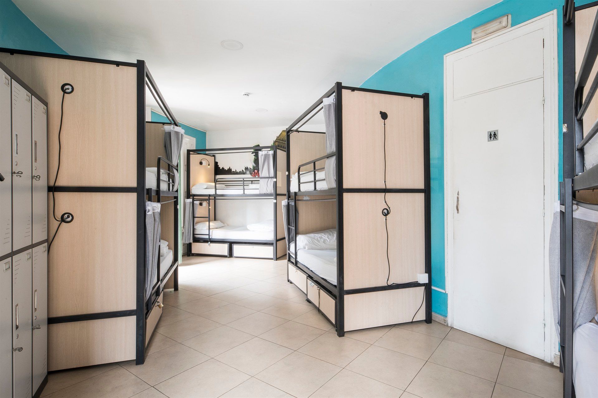 A room with bunk beds and lockers in a hostel.