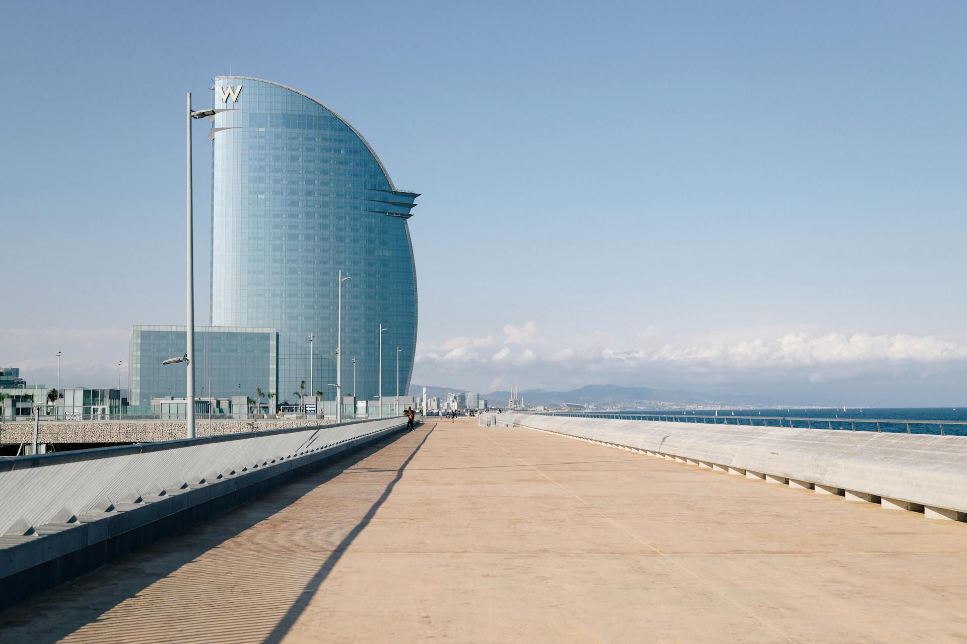 A large building is sitting on top of a sandy beach next to the ocean.