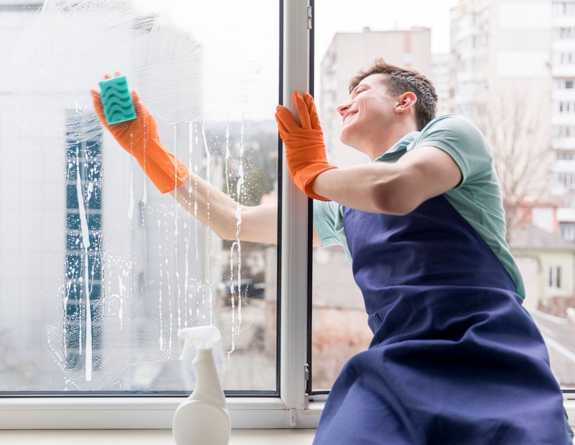 a man is cleaning a window with a sponge .