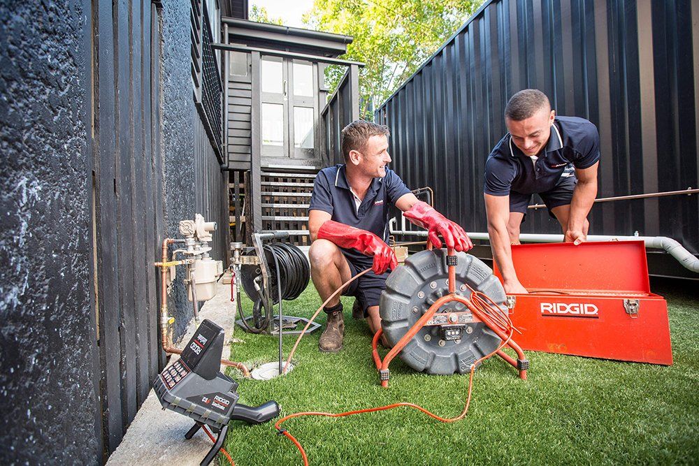 Two Plumbers Happily Doing Their Work — Unblock Pipe Clearing in Mullumbimby, NSW