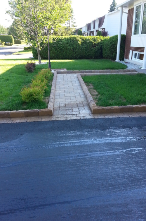 Une allée en briques menant à une maison dans un quartier résidentiel