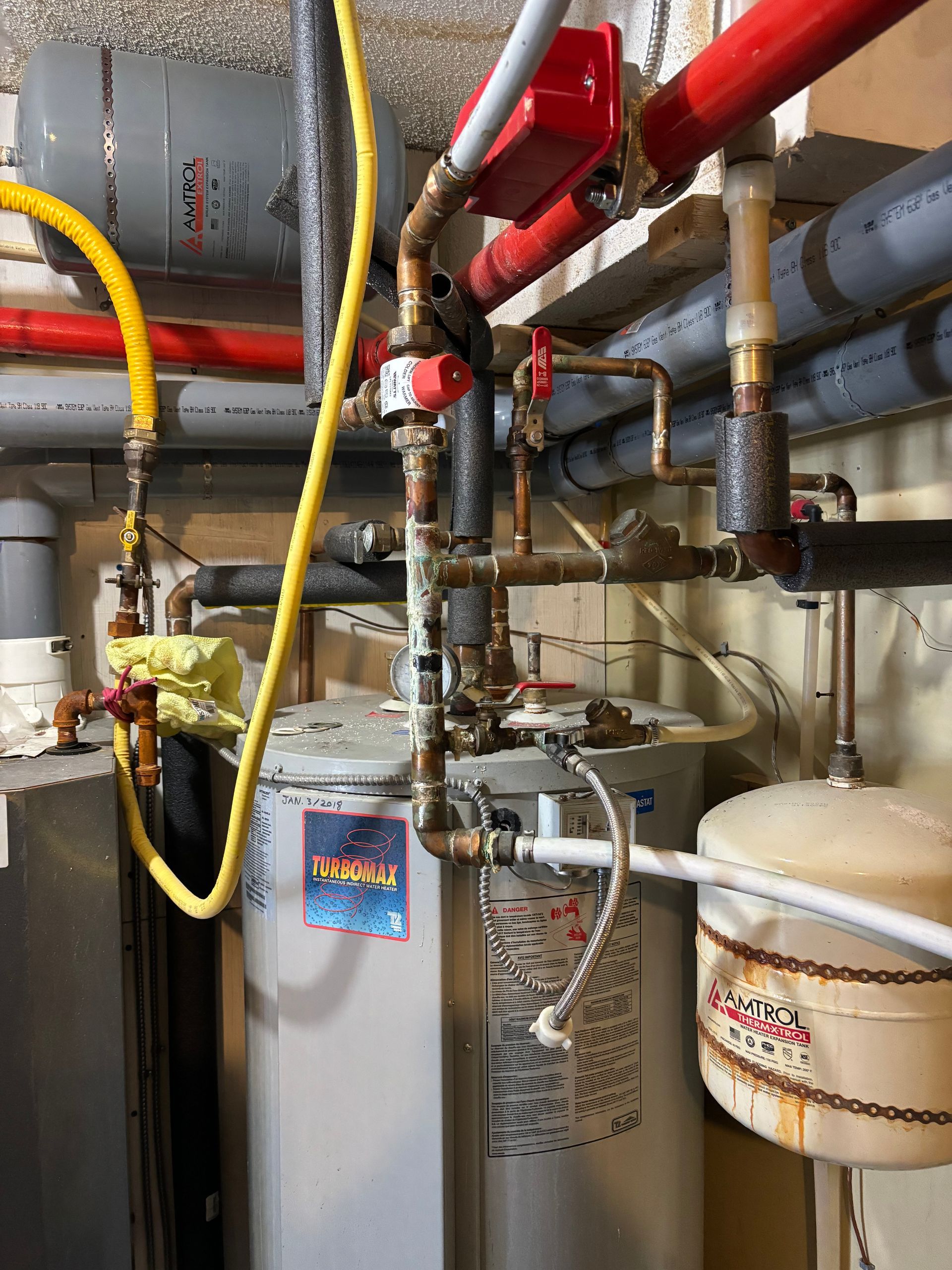 A plumber is working on a water filter in a bathroom.