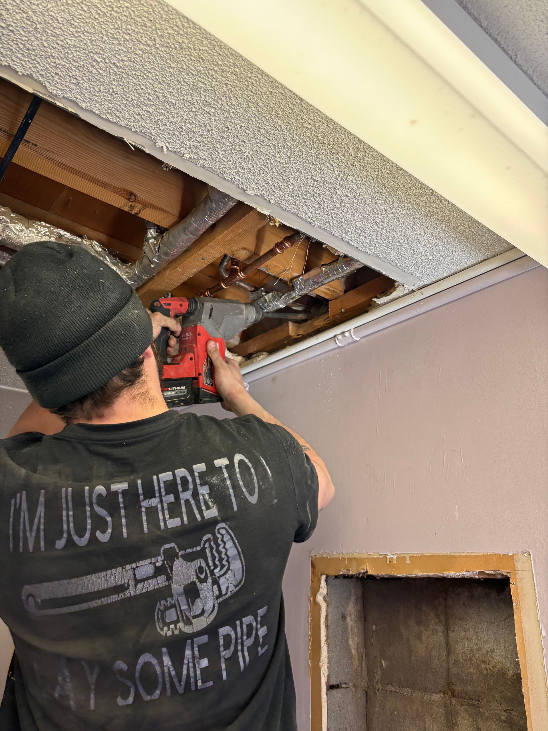 A plumber is fixing a faucet in a kitchen.
