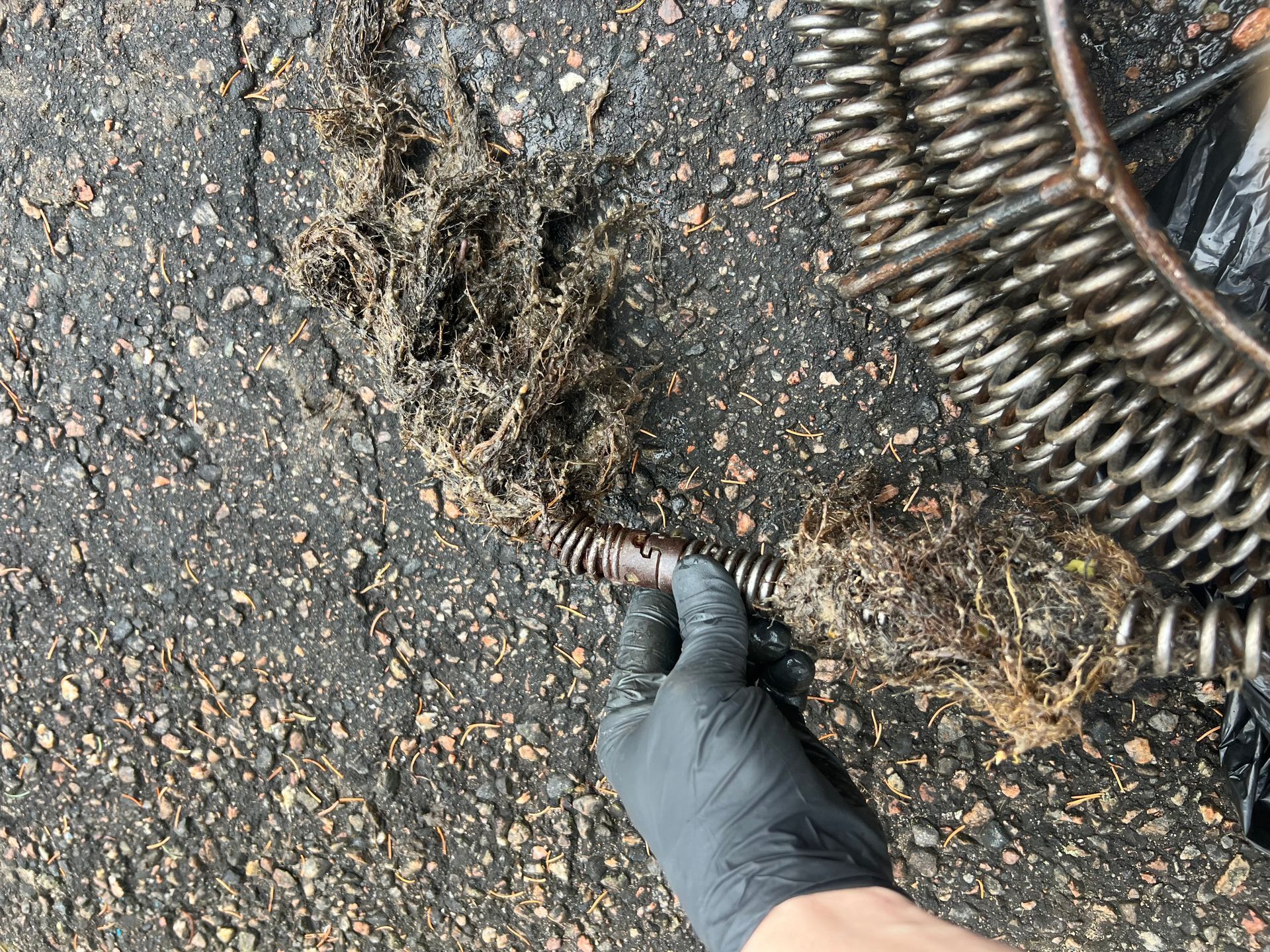 A plumber is fixing a sink in a kitchen with a flashlight.