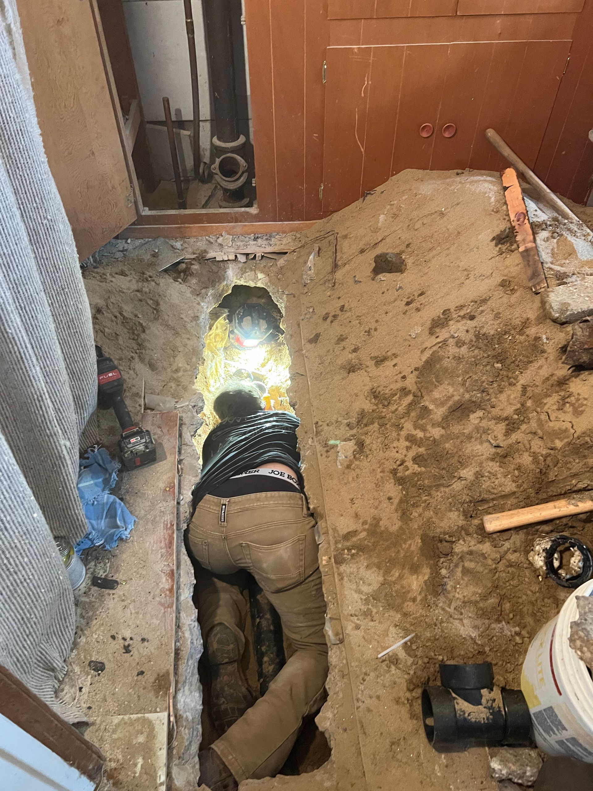 A man is laying in a hole in the ground.