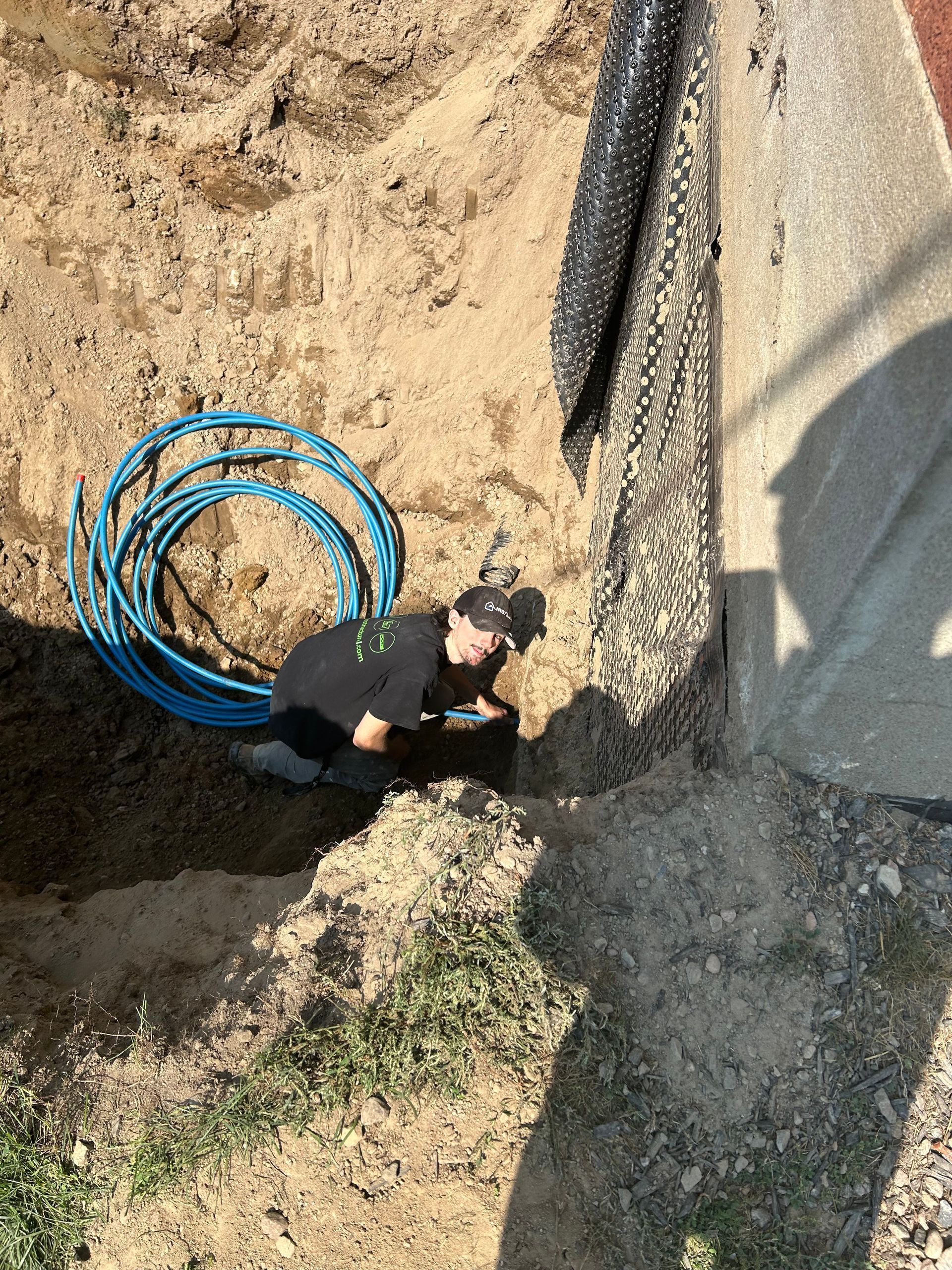 A man is fixing a bathtub with a screwdriver in a bathroom.
