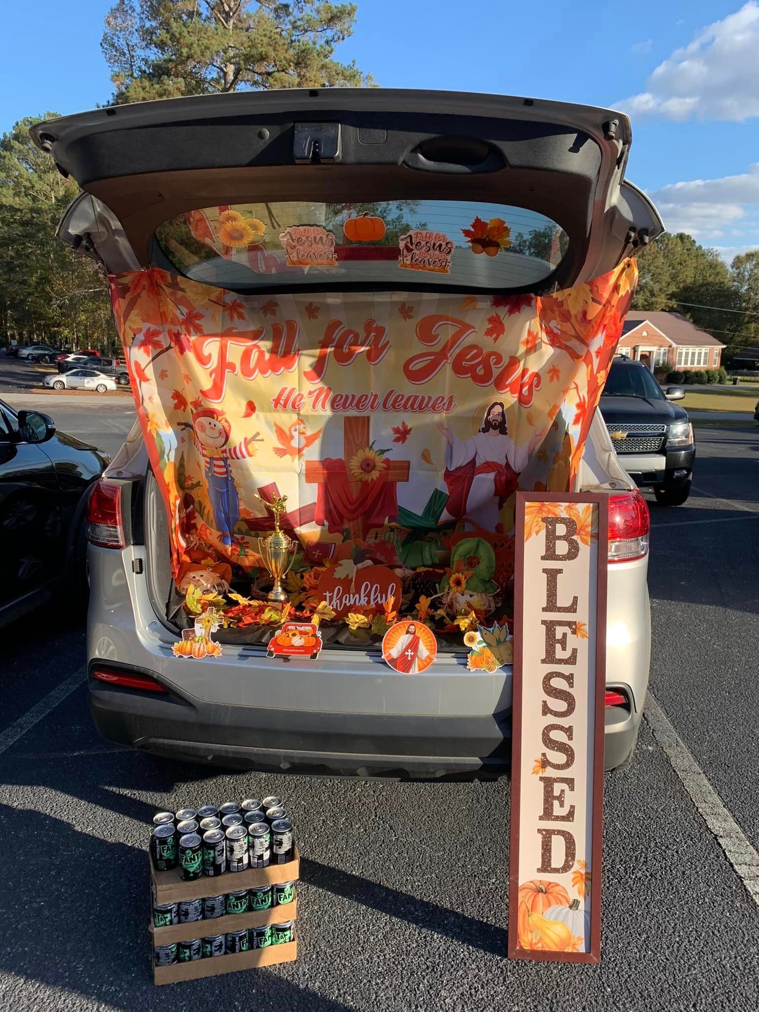 The trunk of a car is decorated for thanksgiving with pumpkins and a sign that says blessed.