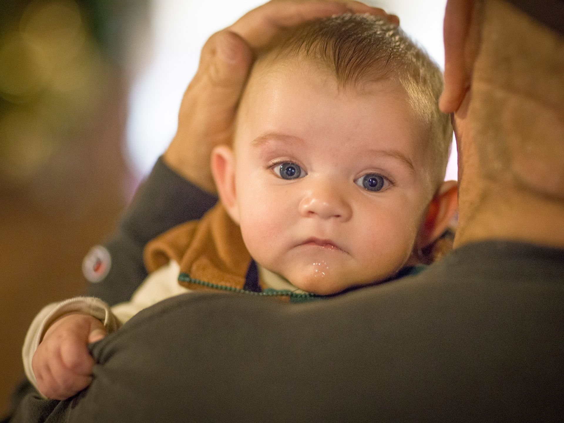 A man is holding a baby in his arms.