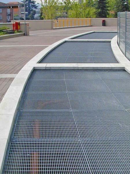 Una passerella metallica con una recinzione sullo sfondo.