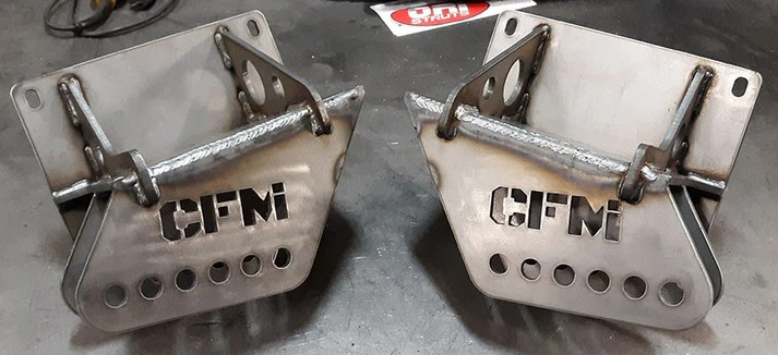 A lifted, brown and white Chevy Blazer with large off-road tires, parked in a grassy area.