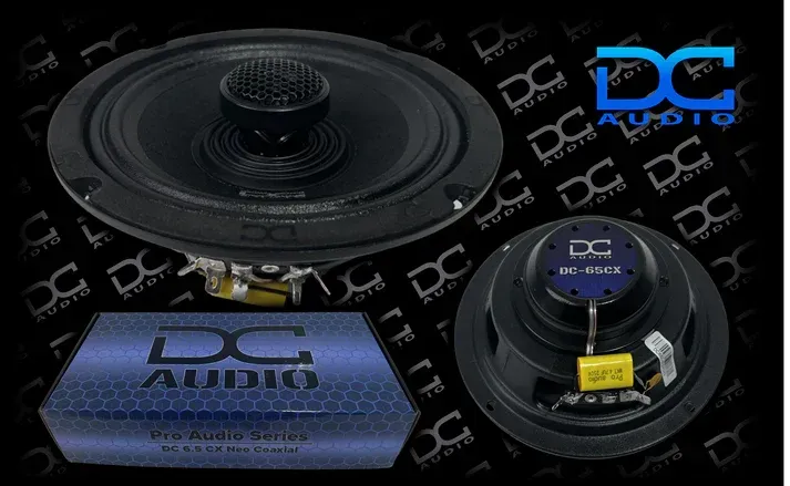 A pair of dc audio speakers are sitting on top of each other on a black background.