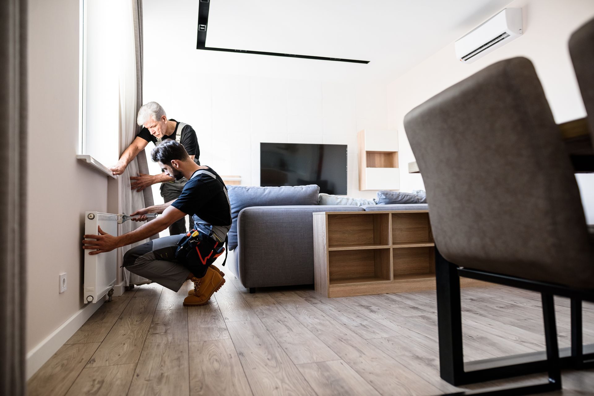 Two men are inspecting a radiator.