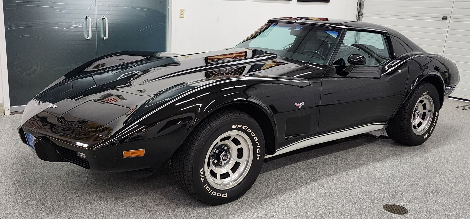 Black classic Corvette parked in a garage.