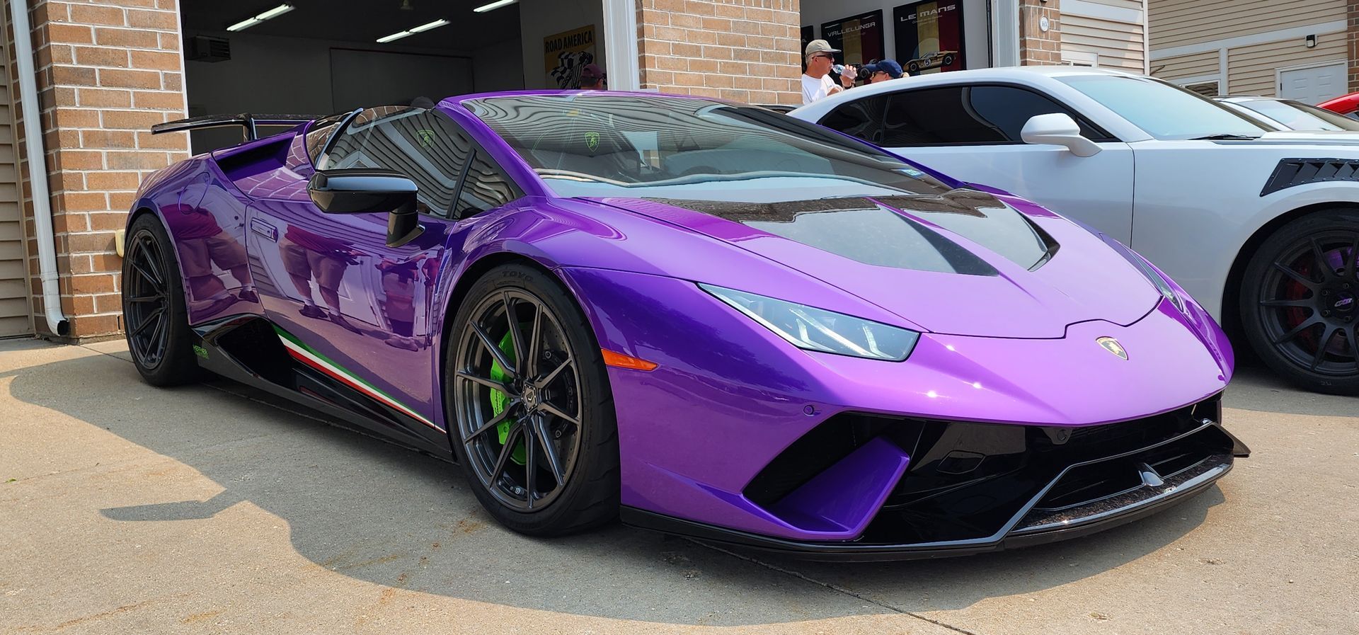 Purple Lamborghini sports car with green brake calipers.