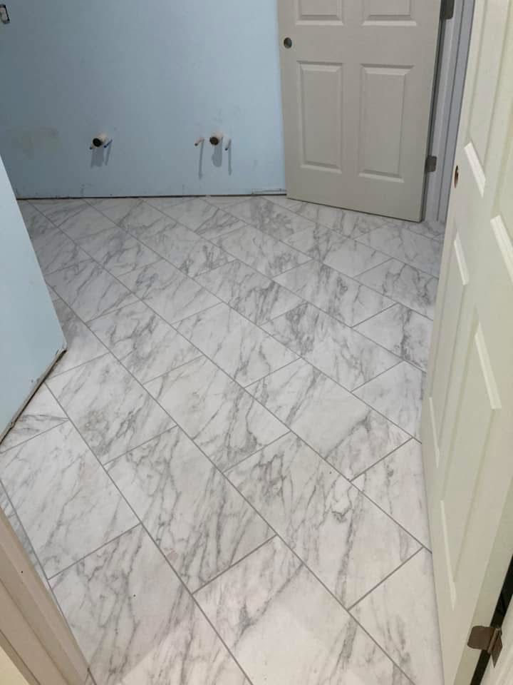 Room with marble-patterned tile floor, pale blue wall, and white doors.