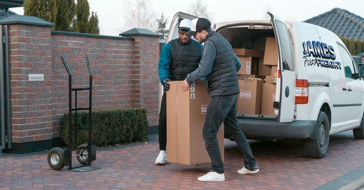 Two Men Are Carrying A Cardboard Box to be delivered— James Fast Freight in Wagga Wagga, NSW