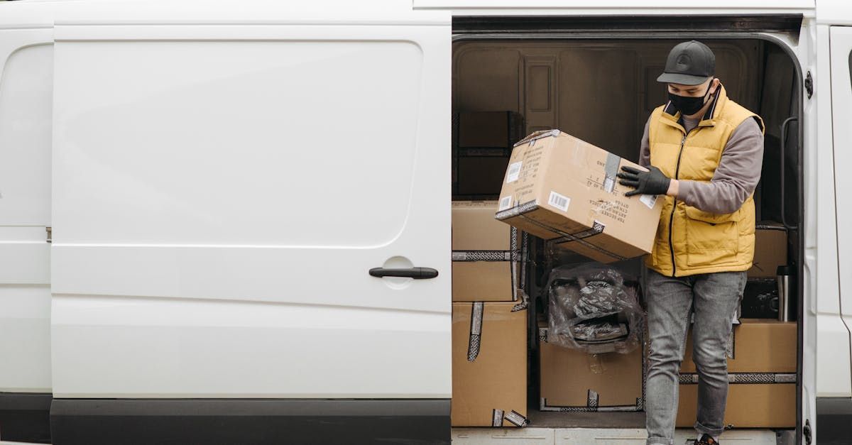 Two Delivery Men Are Loading Boxes Into A Van — James Fast Freight in Wodonga, NSW
