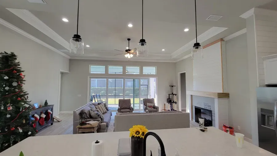 Open-concept living space with Christmas tree, fireplace, seating area, and kitchen island.