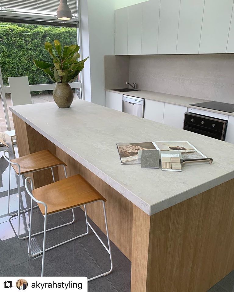 A Kitchen With A Large Island And Stools And A Plant On The Counter — Southeast Stone Pty Ltd In Caloundra West, QLD