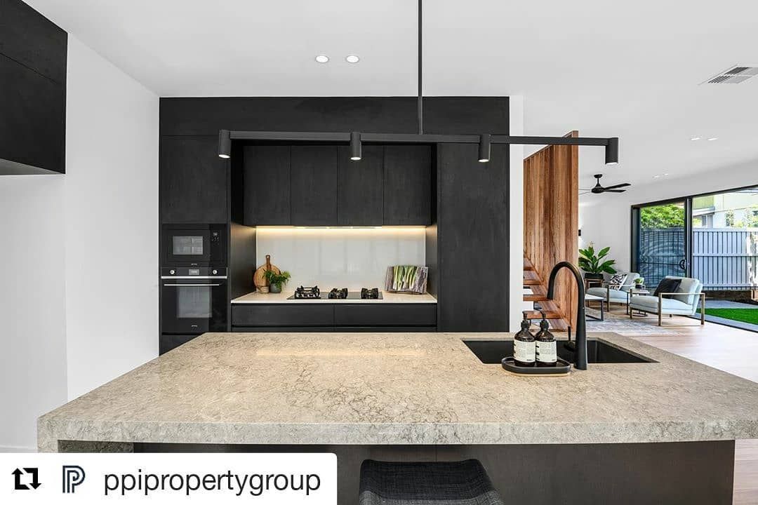 A Kitchen With Black Cabinets And A Granite Counter Top — Southeast Stone Pty Ltd In Gold Coast, QLD
