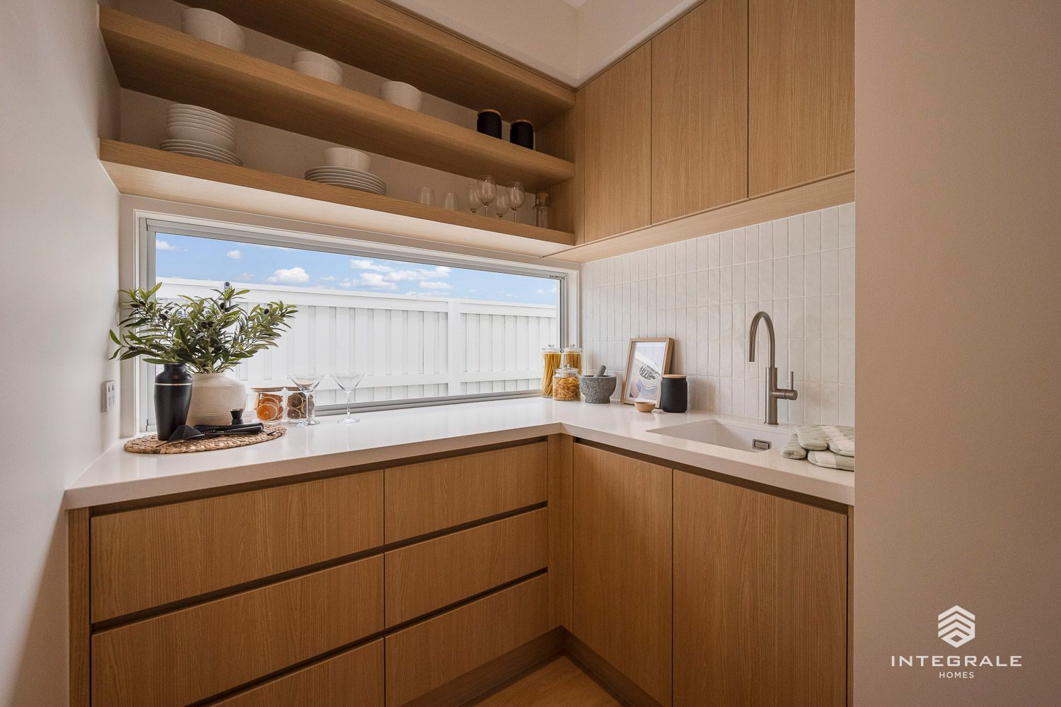 A bright, wood-paneled pantry with a window, shelves, and a sink — Southeast Stone Pty Ltd In Caloundra West, QLD