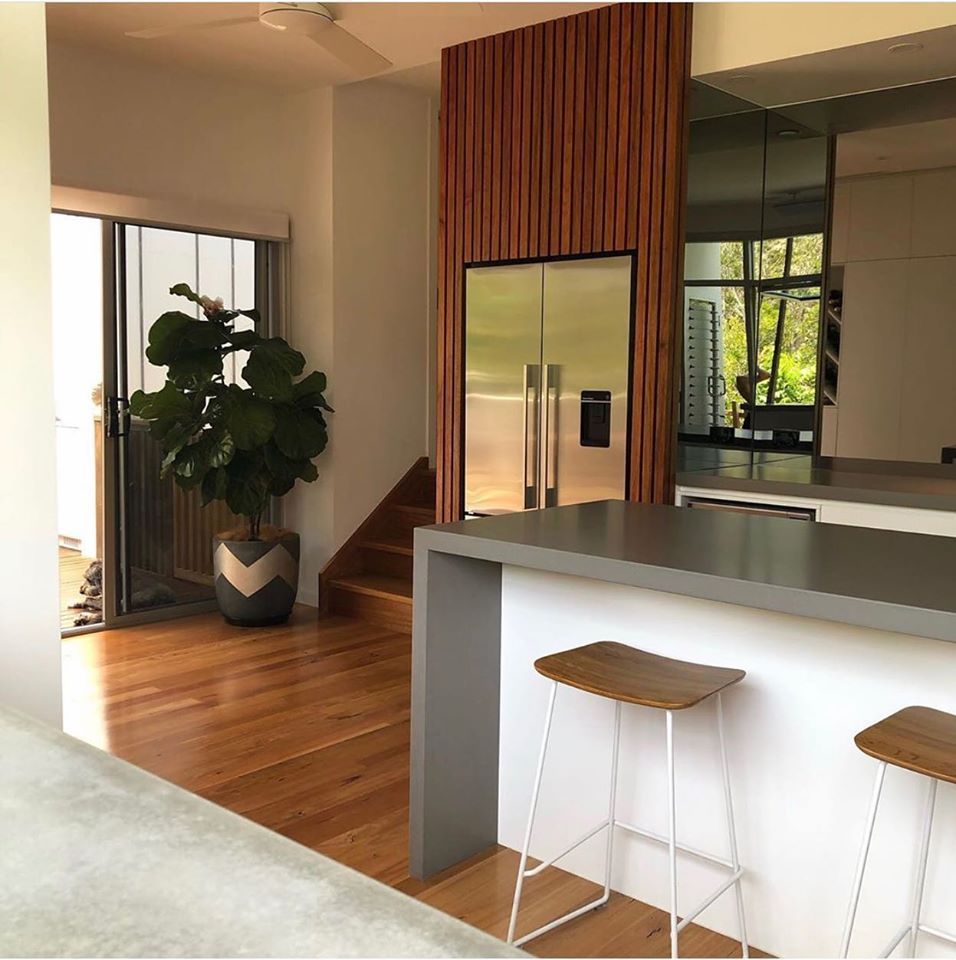 A Kitchen With A Stainless Steel Refrigerator And Stools — Southeast Stone Pty Ltd In Caloundra West, QLD