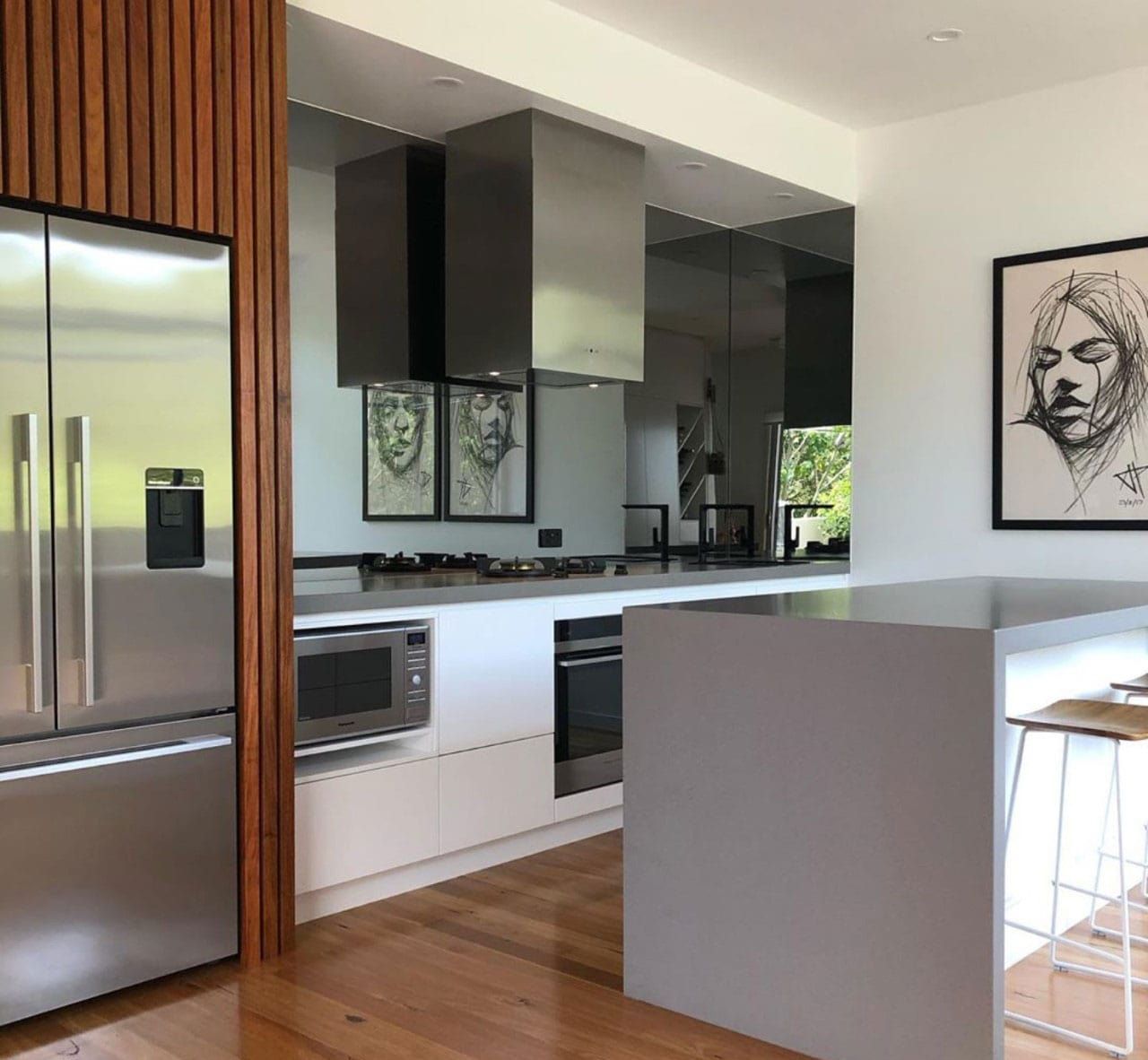A Kitchen With Stainless Steel Appliances And A Painting On The Wall — Southeast Stone Pty Ltd In Gold Coast, QLD