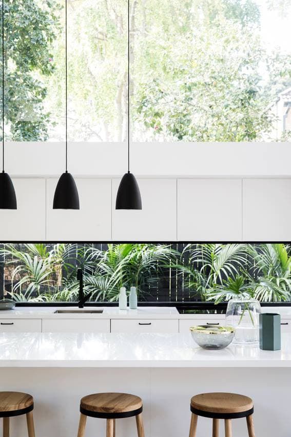 A Kitchen With White Cabinets, Wooden Stools and a Large Window  — Southeast Stone Pty Ltd In Caloundra West, QLD